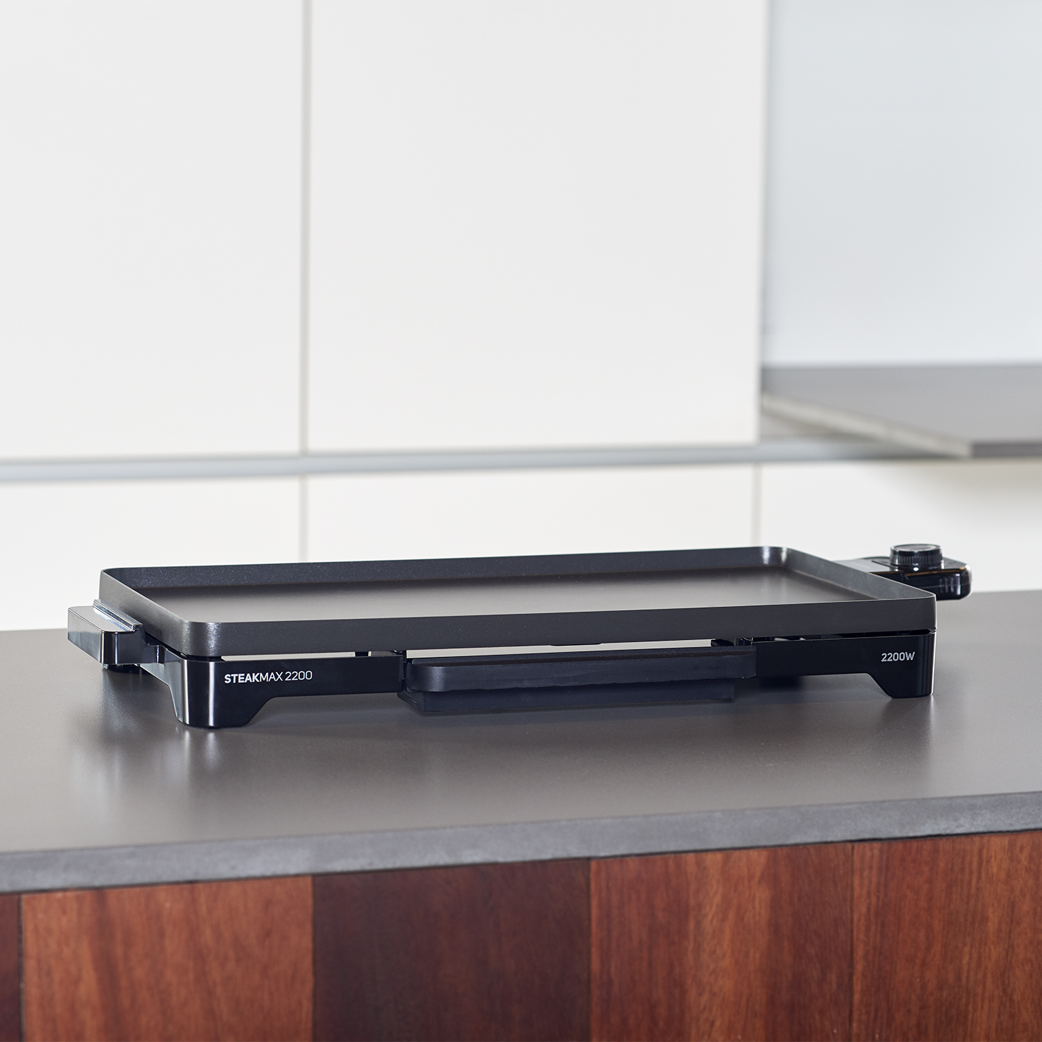 Una plancha negra se muestra sobre un fondo blanco. El texto dice: STEAKMAX 2200W.