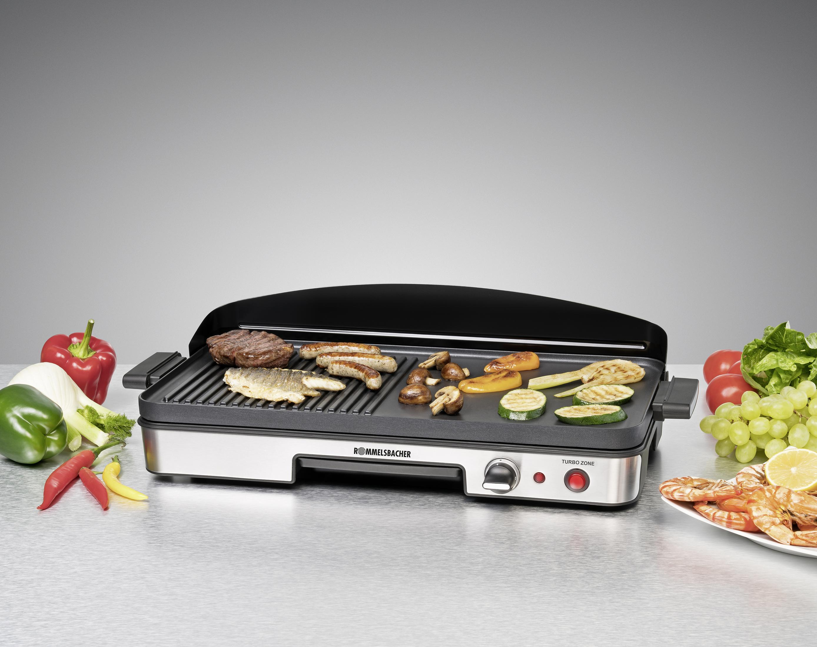 Gril électrique avec aliments, dont viande, légumes et fruits. Une surface grise en arrière-plan.