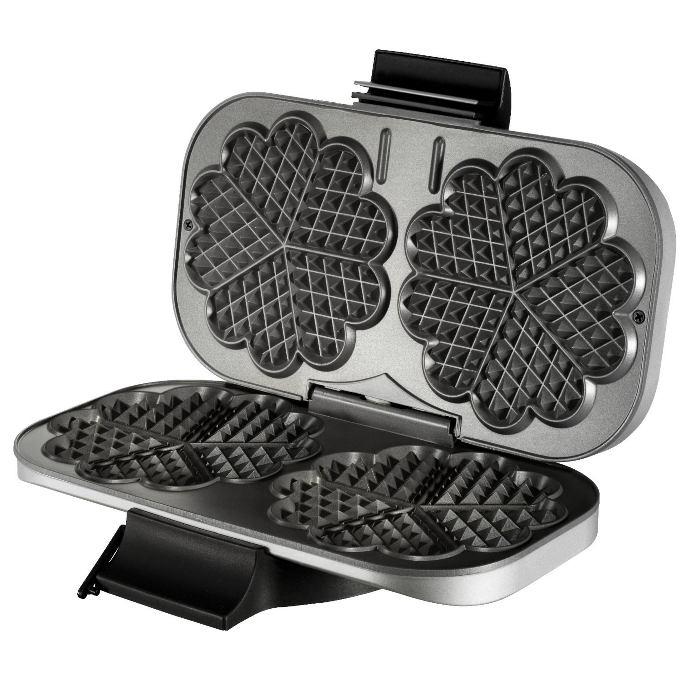 Silberner Waffeleisen offen. Es ist mit Waffeln gefüllt. Es gibt vier kleeblattförmige Waffeln.