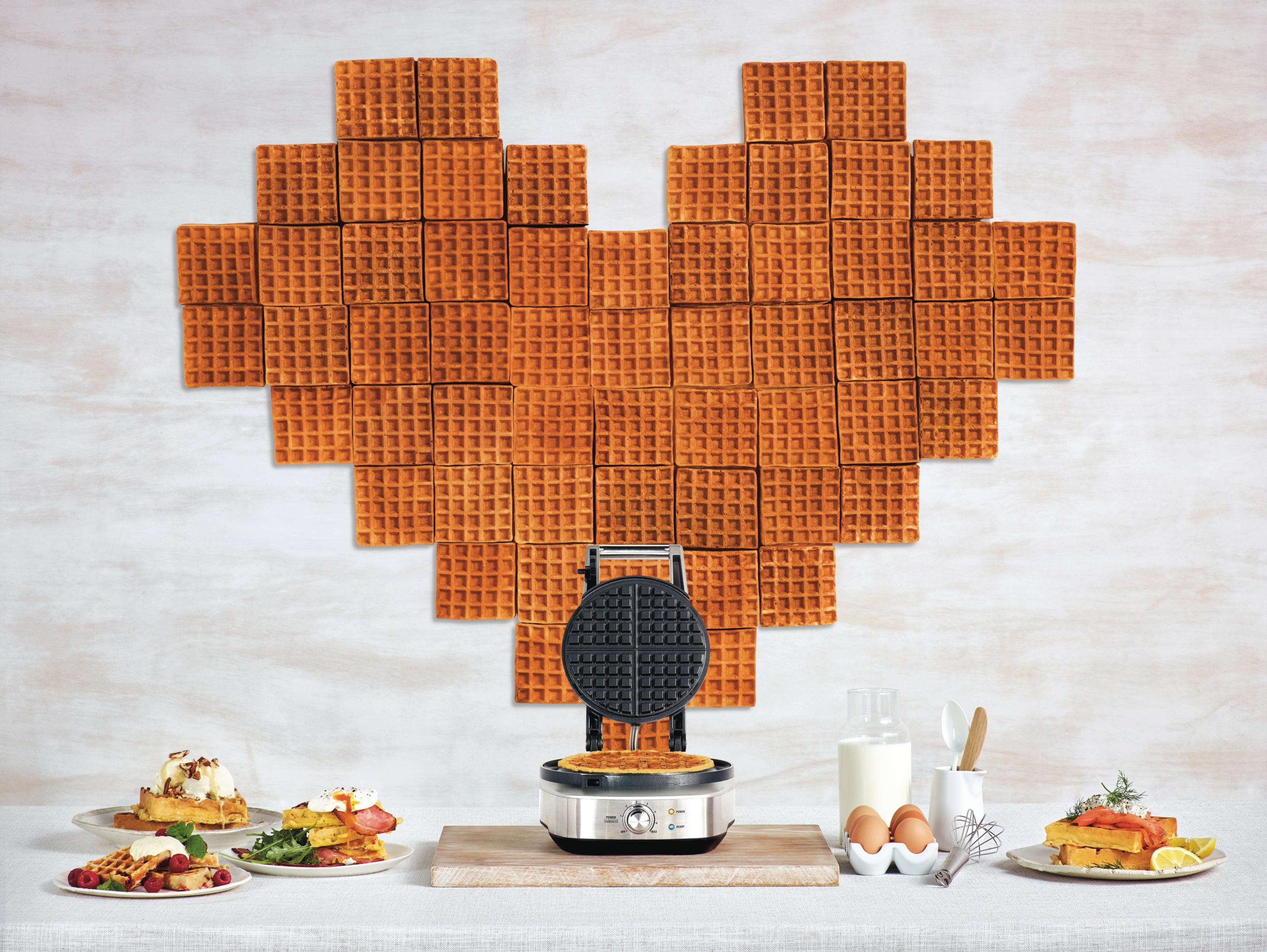 Gofrnica robi gofra. Gofry ułożone w kształt serca. Produkty spożywcze i składniki.