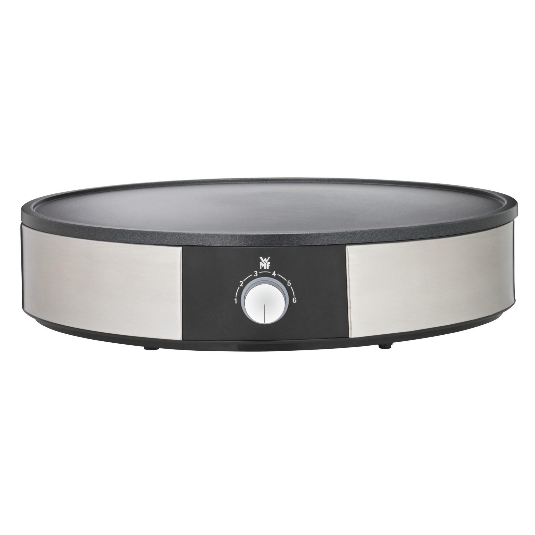 Okrągła, srebrna płyta do smażenia z czarną powierzchnią do gotowania, na białym tle.