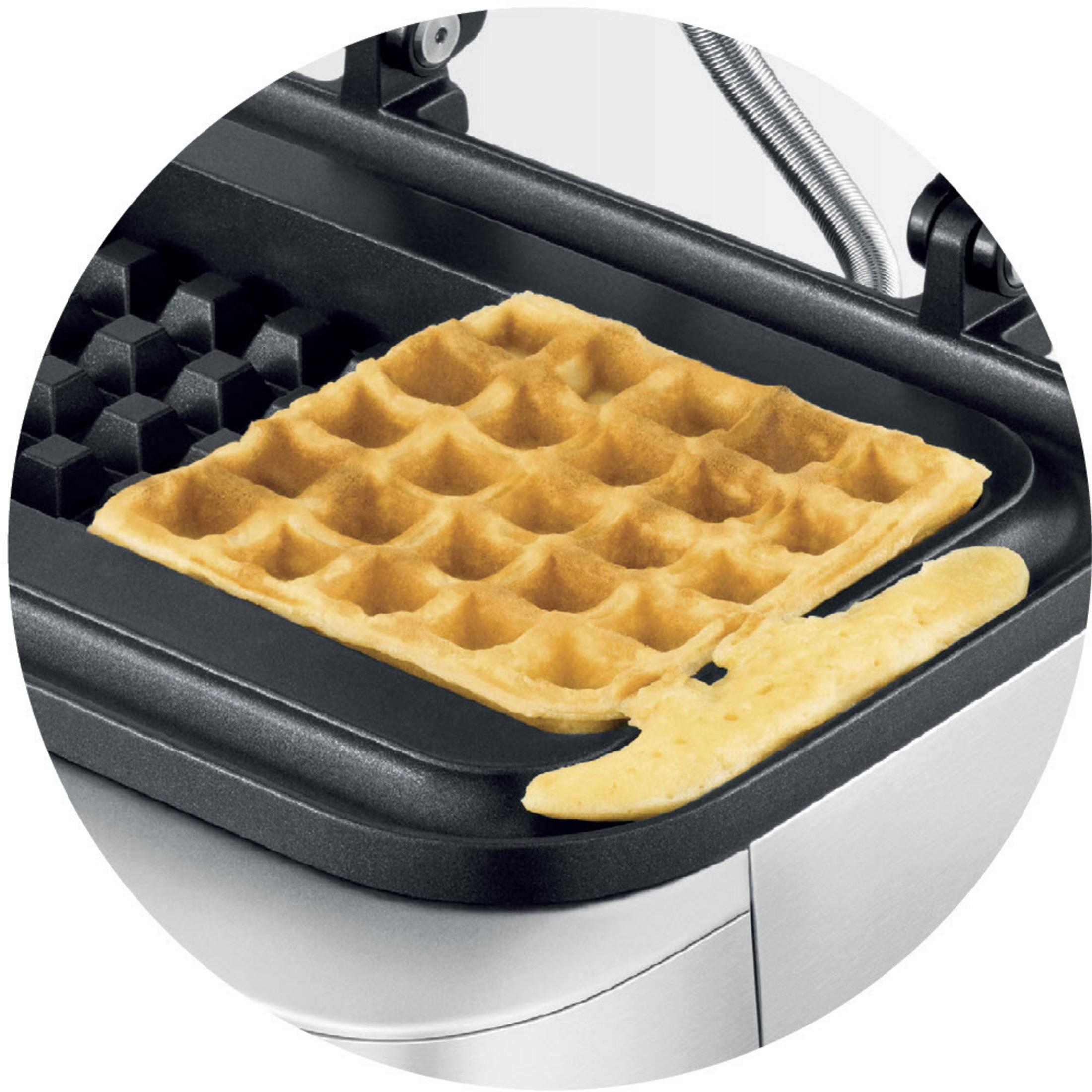Eine Waffel in einem Waffeleisen, mit einem abgebrochenen Stück.
