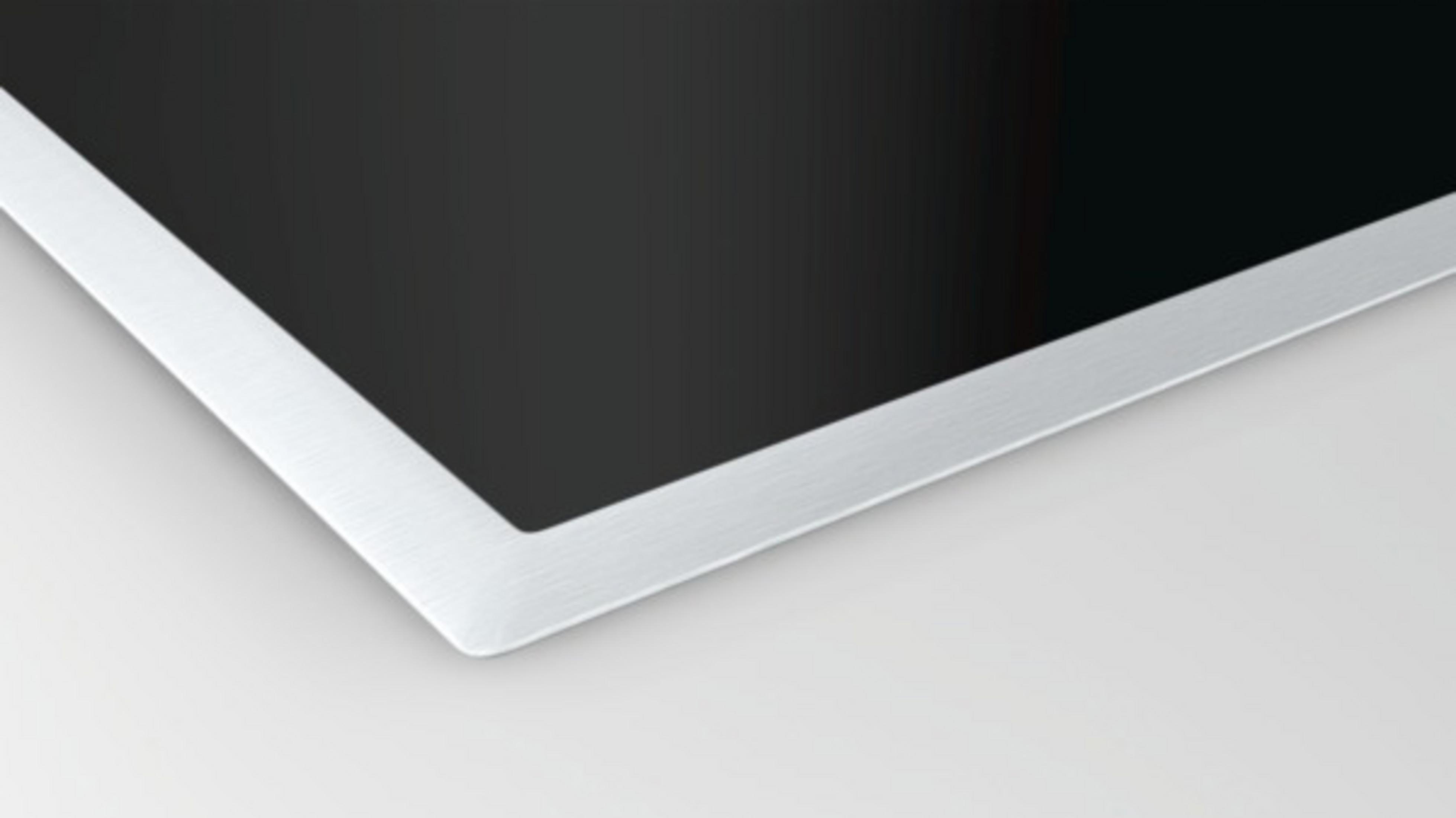 Zbliżenie czarnej płyty grzewczej ze srebrną krawędzią na białym tle.