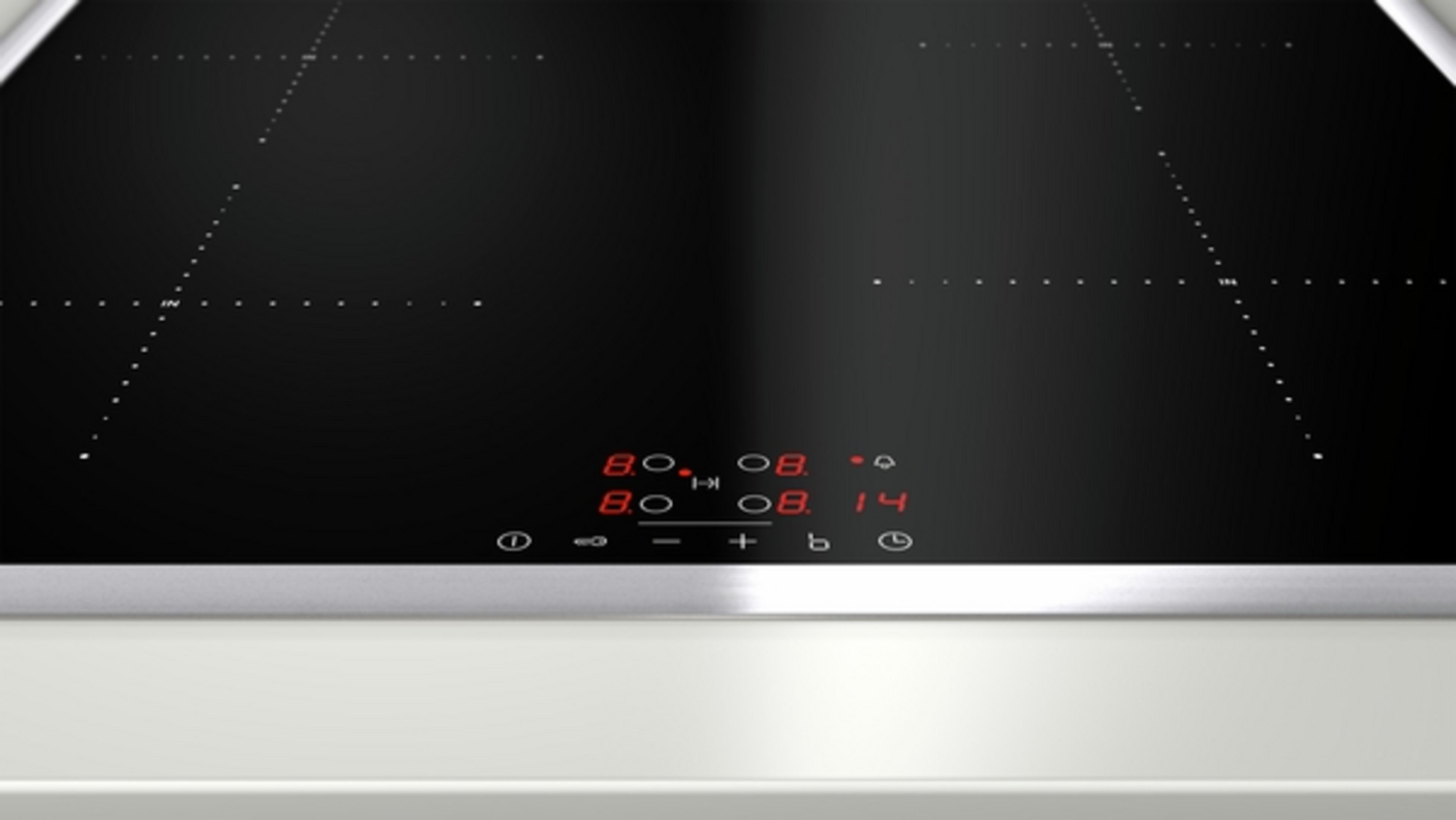 Table de cuisson à induction noire avec affichage numérique, bordure inox et comptoir blanc.