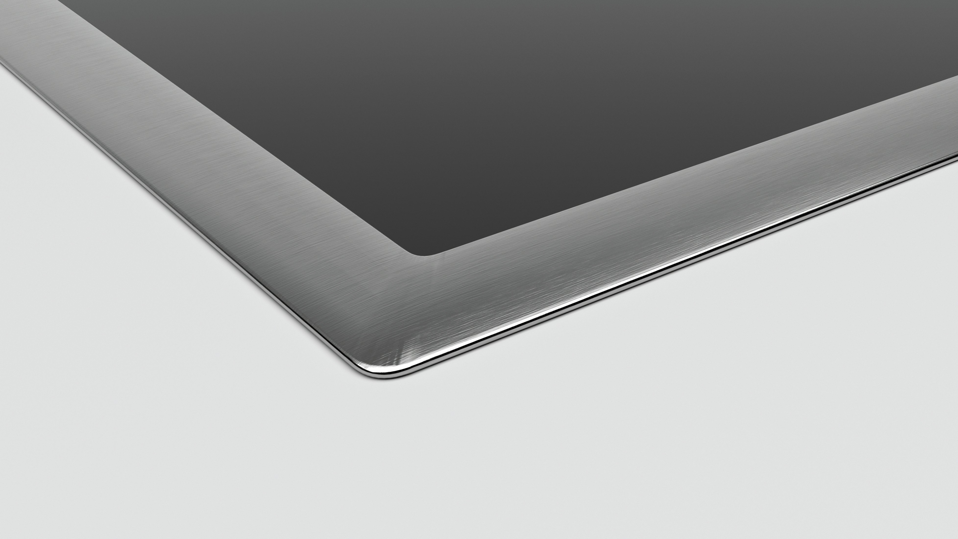 Zbliżenie rogu płyty grzejnej ze stali nierdzewnej i czerni.