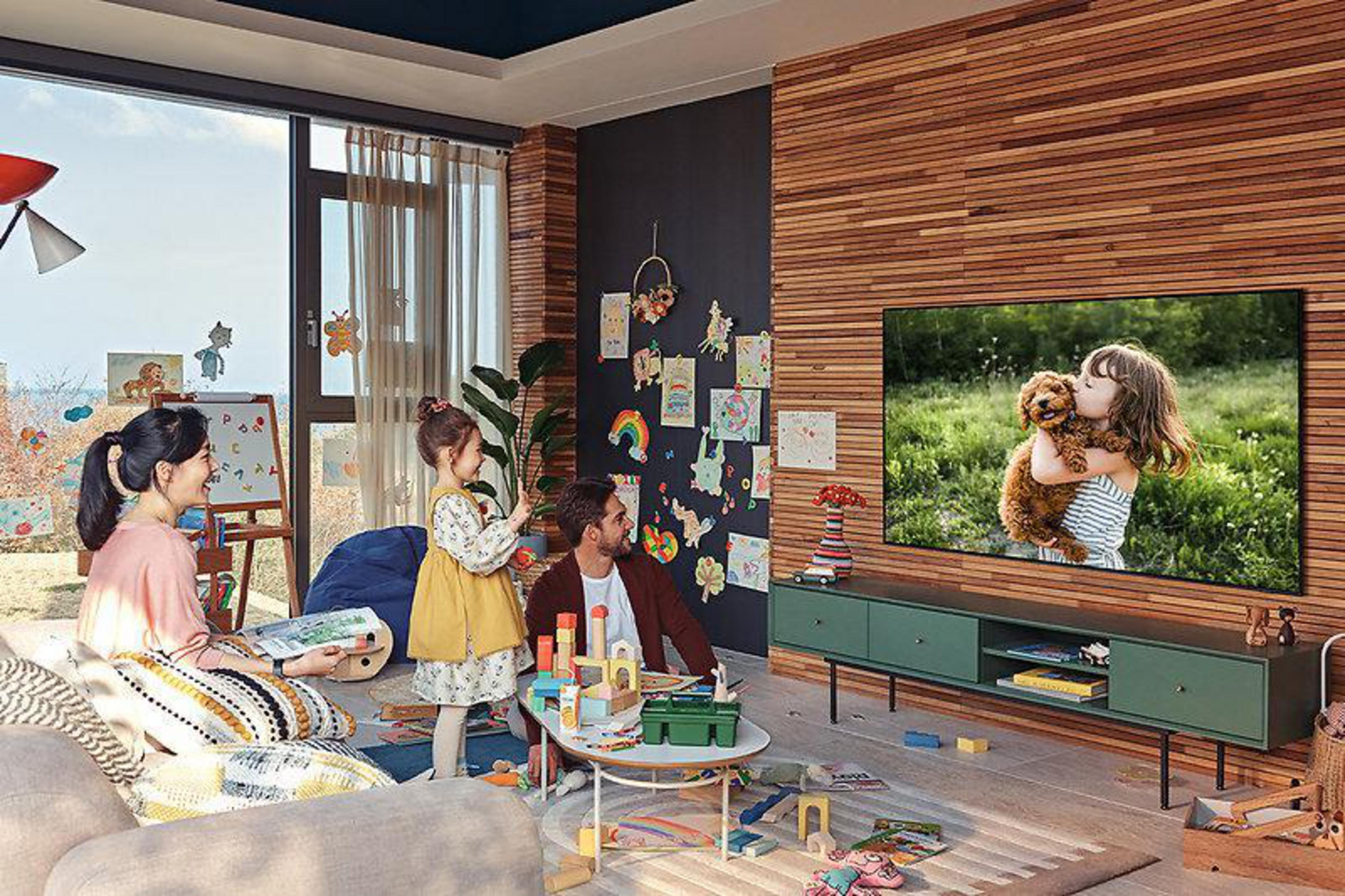 Rodzina ogląda telewizję w salonie z widokiem na słońce.