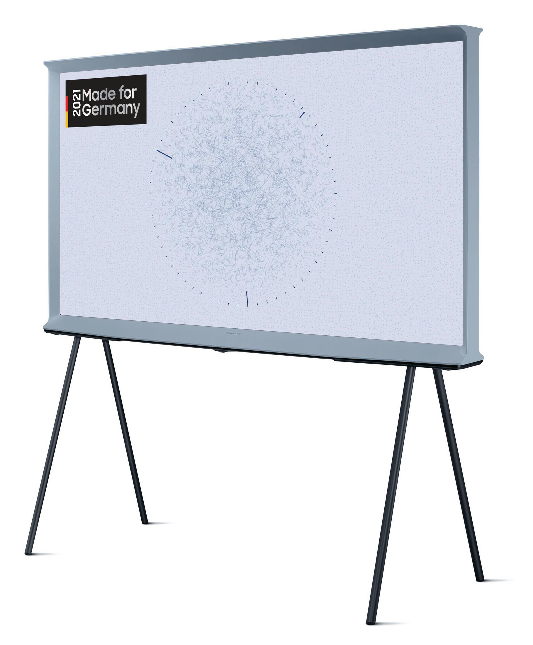 Nowoczesny, szary telewizor na czarnym stojaku. Ekran wyświetla jasnoniebieski, abstrakcyjny wzór.