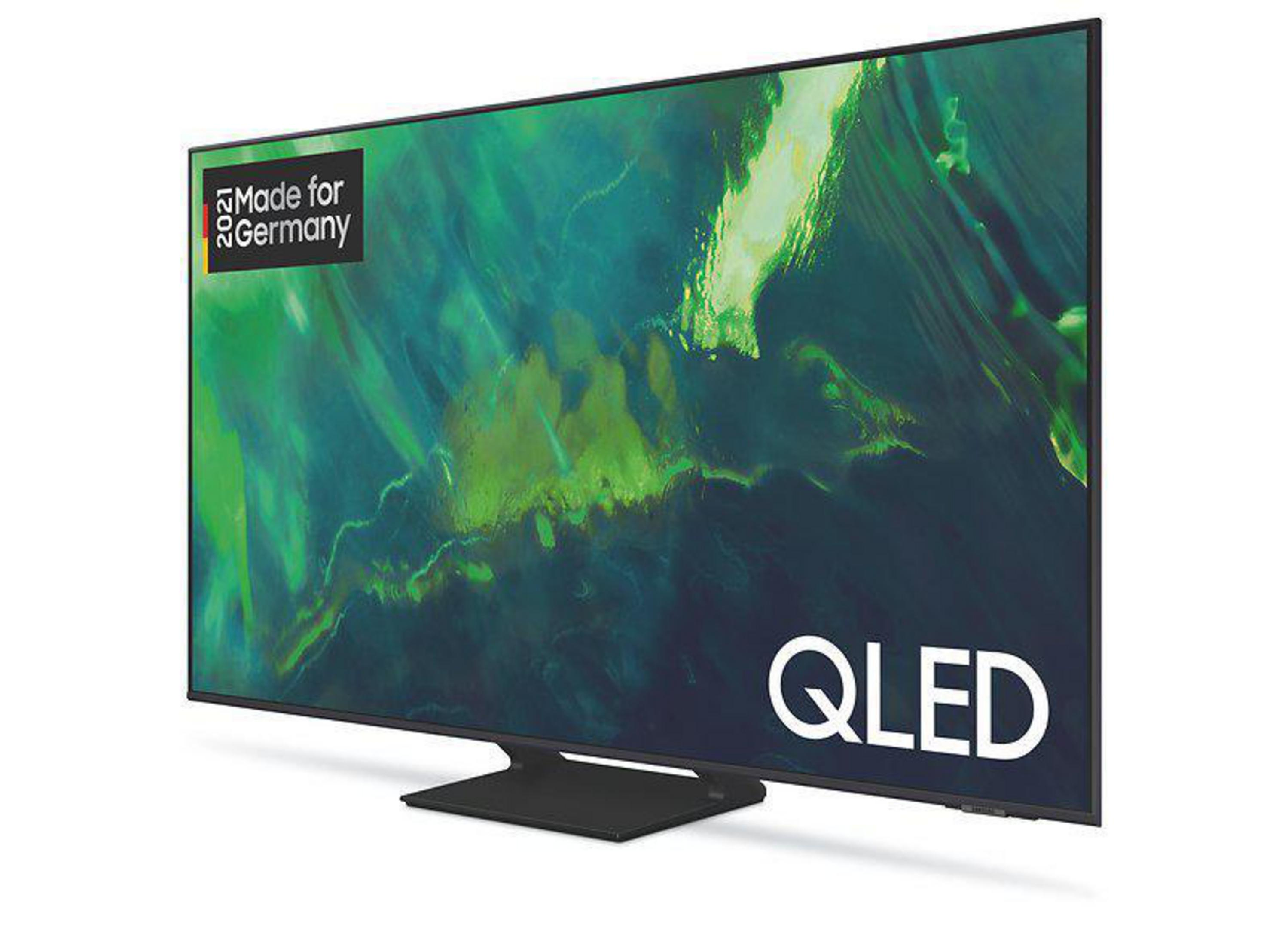 Telewizor QLED na stojaku z zielonym i białym tłem oraz napisem Made for Germany.