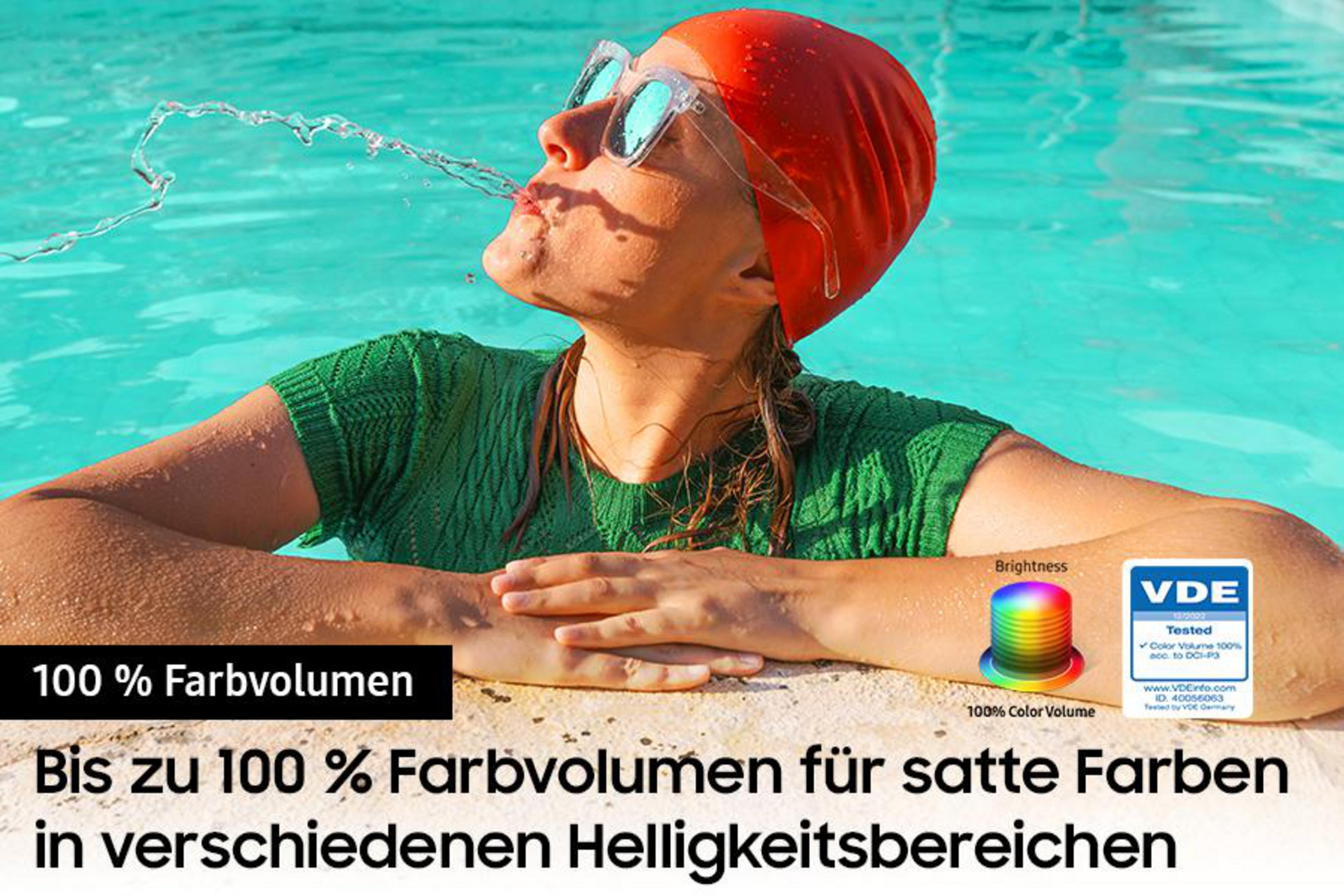 Kobieta pływająca w basenie, woda tryska z jej ust. Logo VDE i tekst o gamie kolorów.