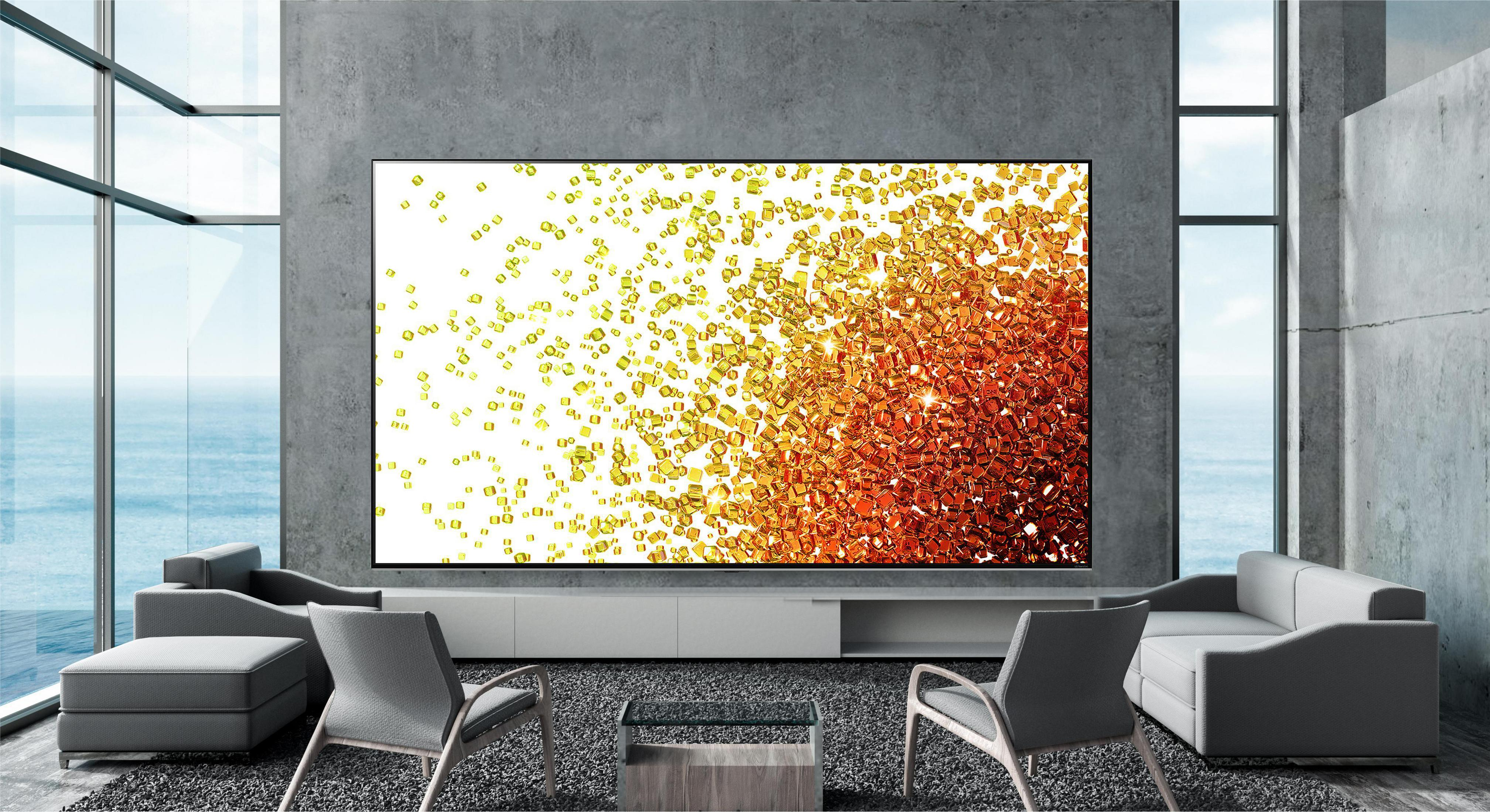 Duży telewizor wyświetla abstrakcyjne złote cząstki na białym ekranie w nowoczesnym salonie.