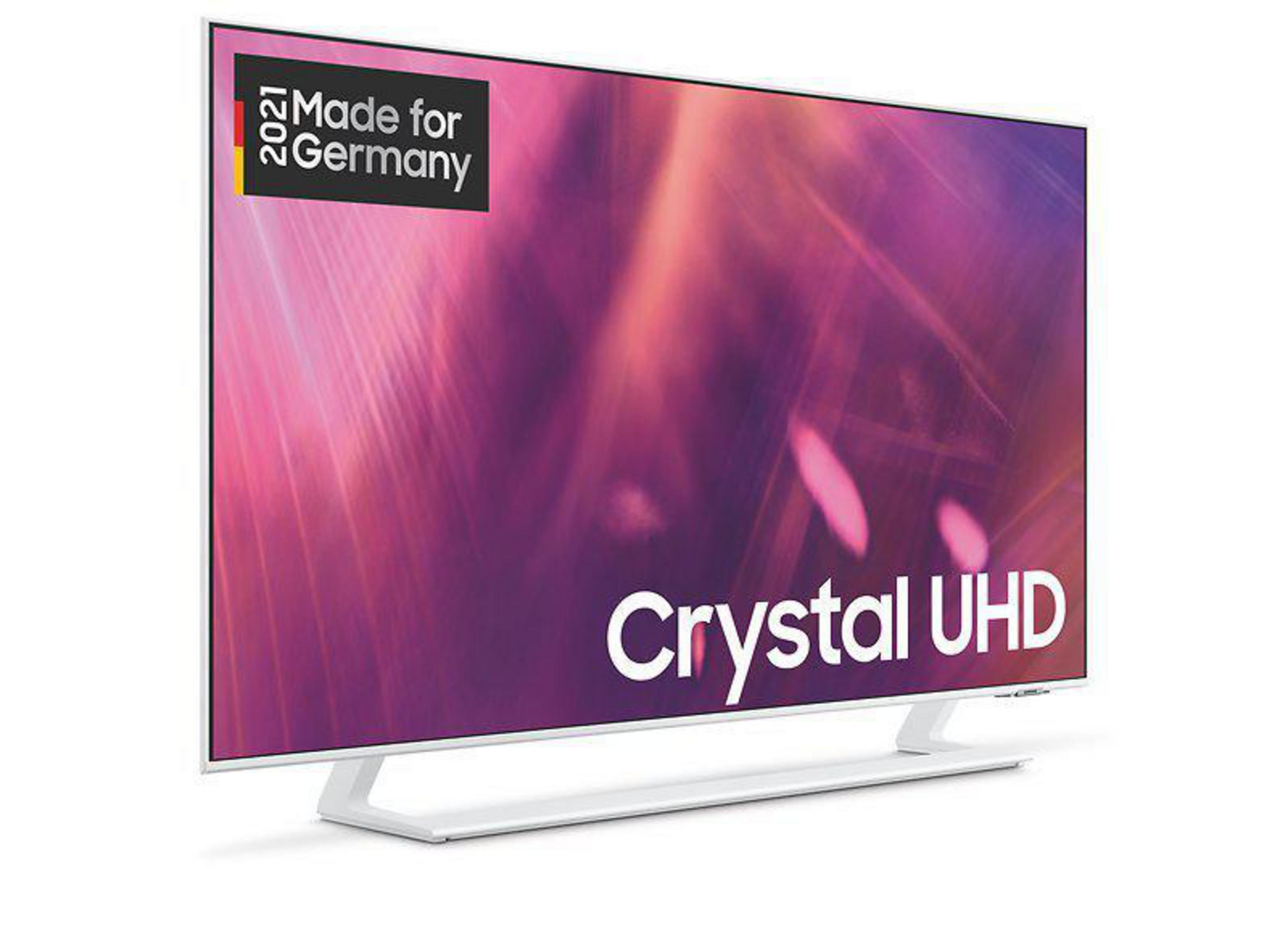 Biały telewizor z logo i napisem 'Crystal UHD'. Biała podstawa. Różowe tło.