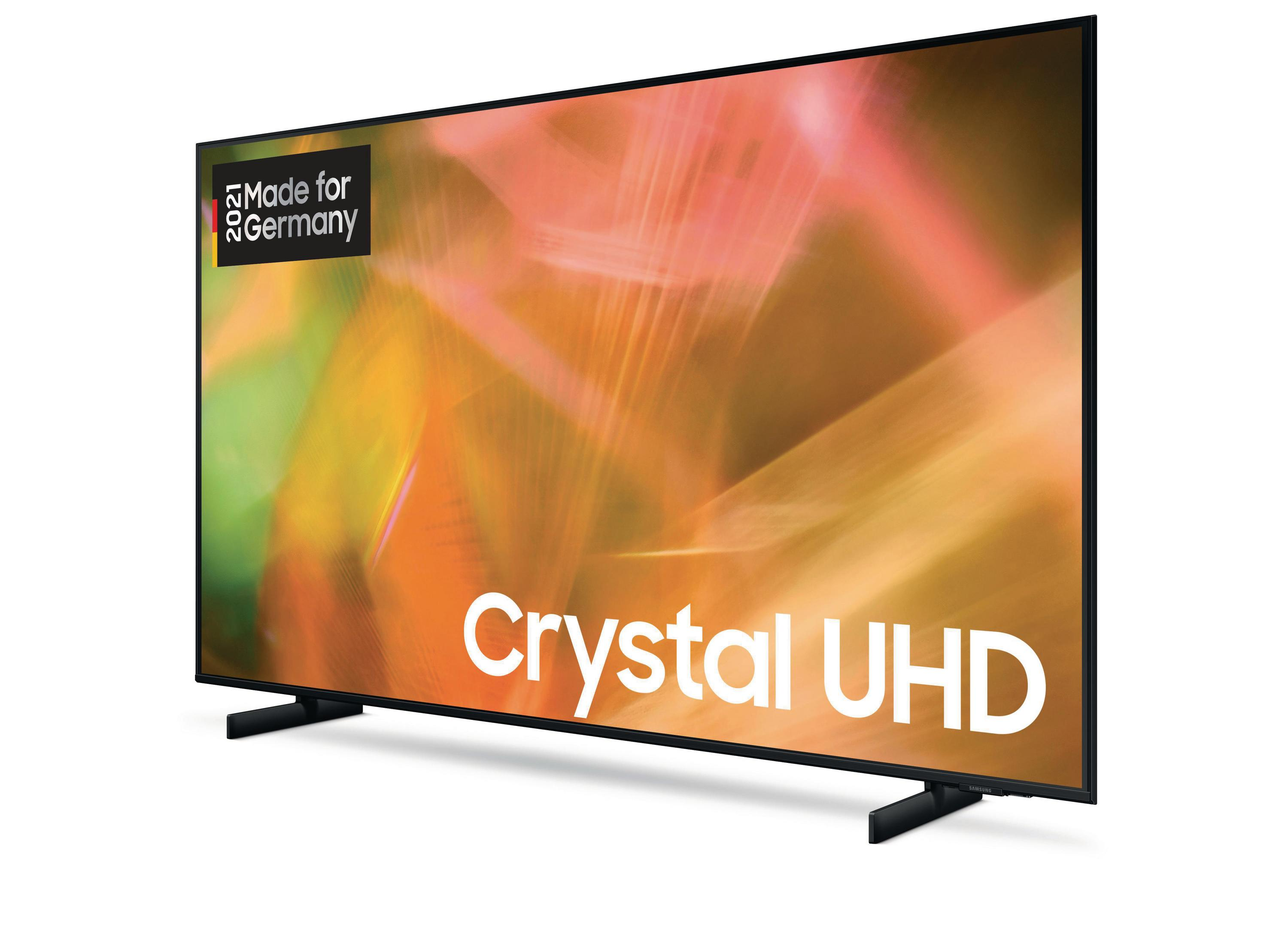 Telewizor z etykietą 'Crystal UHD'. Ma czarną ramę i stoi na dwóch czarnych nóżkach.
