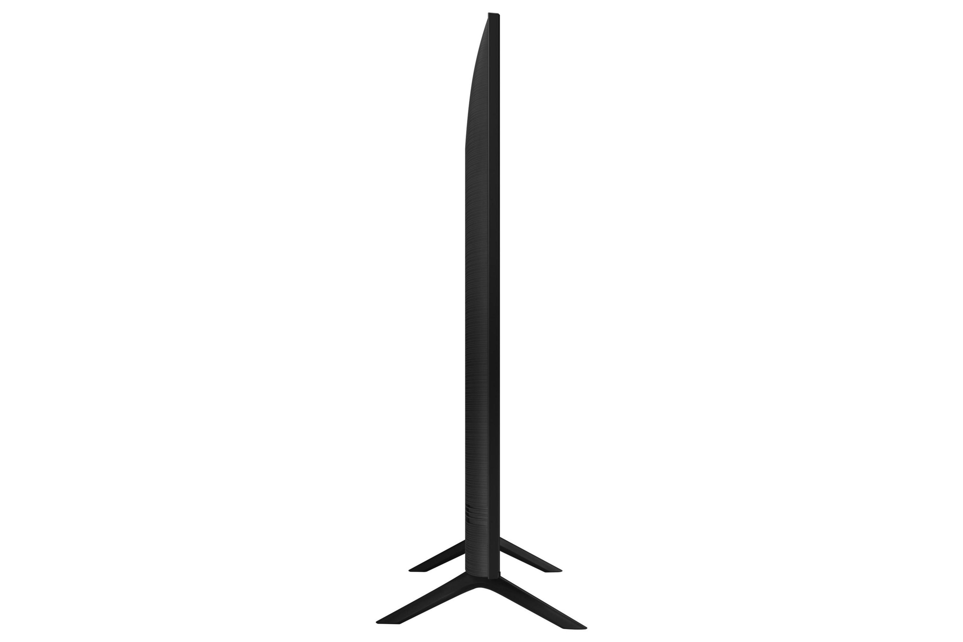 Widok z boku telewizora. Jest czarny, cienki i zamontowany na podstawie. Rama jest bardzo cienka.