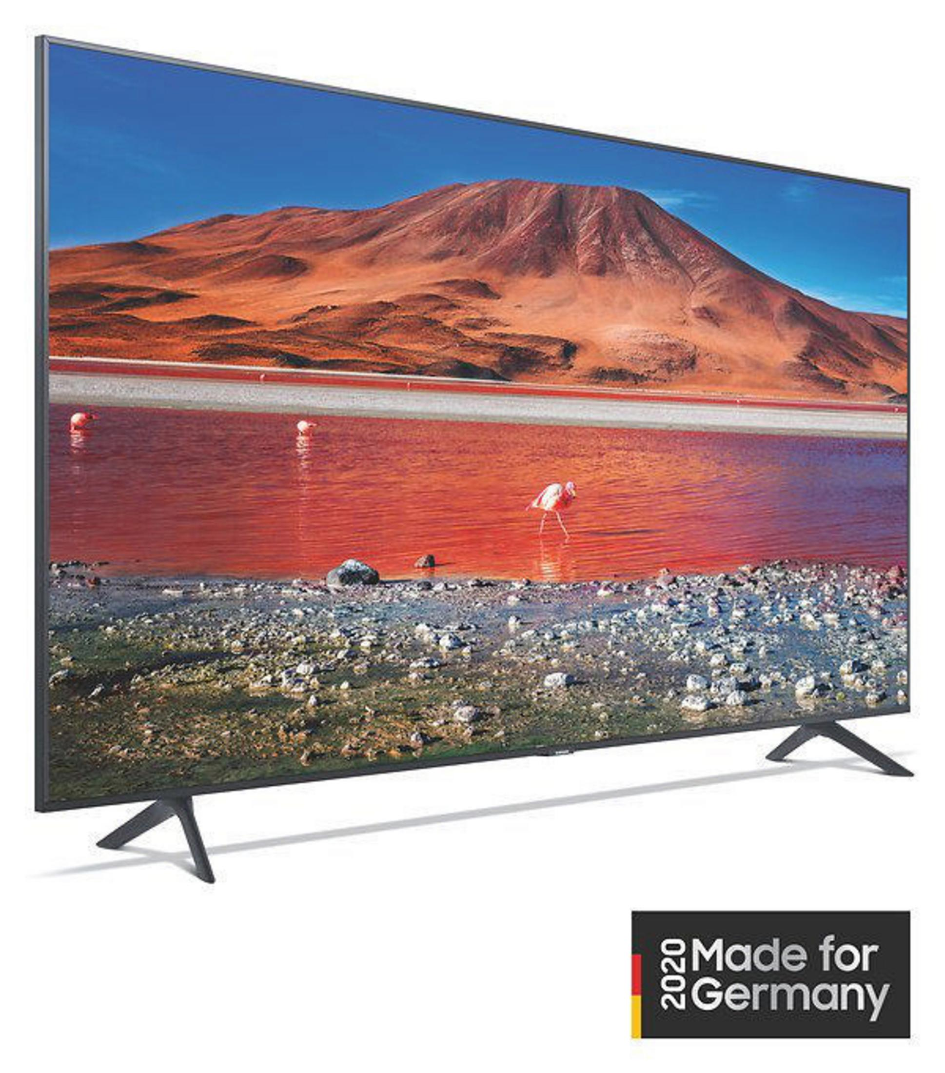 Telewizor wyświetlający krajobraz z czerwonym jeziorem i górami.