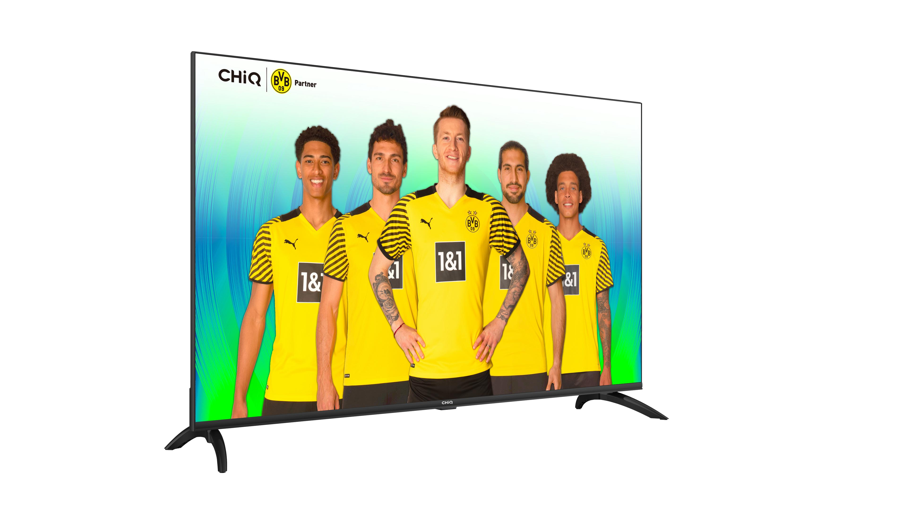CHiQ-Fernseher mit Fußballmannschaft auf dem Bildschirm, grün-blauer Farbverlauf im Hintergrund.