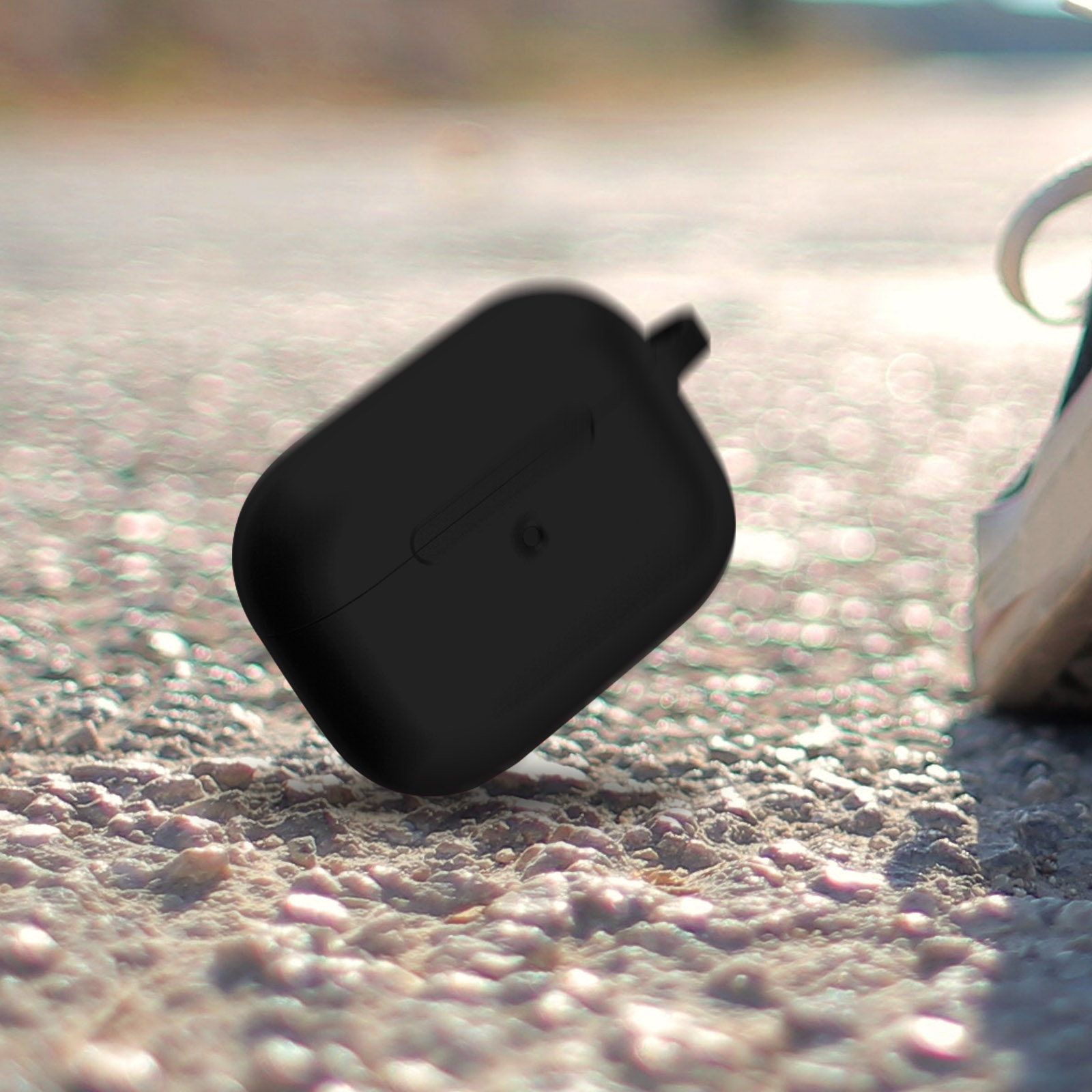 Funda negra de AirPods en superficie texturizada. La funda está ligeramente abierta.