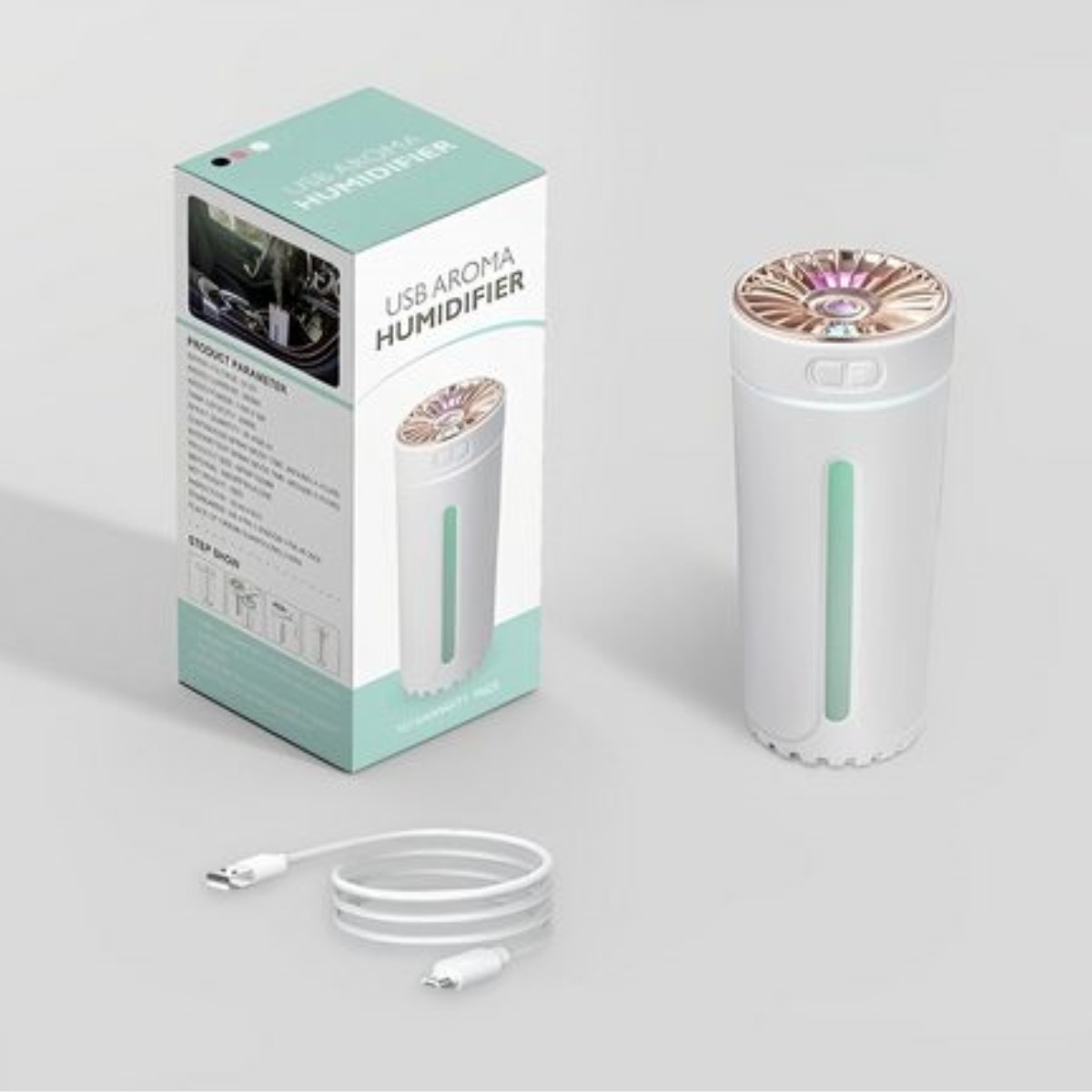 Un humidificador con una caja al lado, un cable USB al frente. Color blanco y dorado.