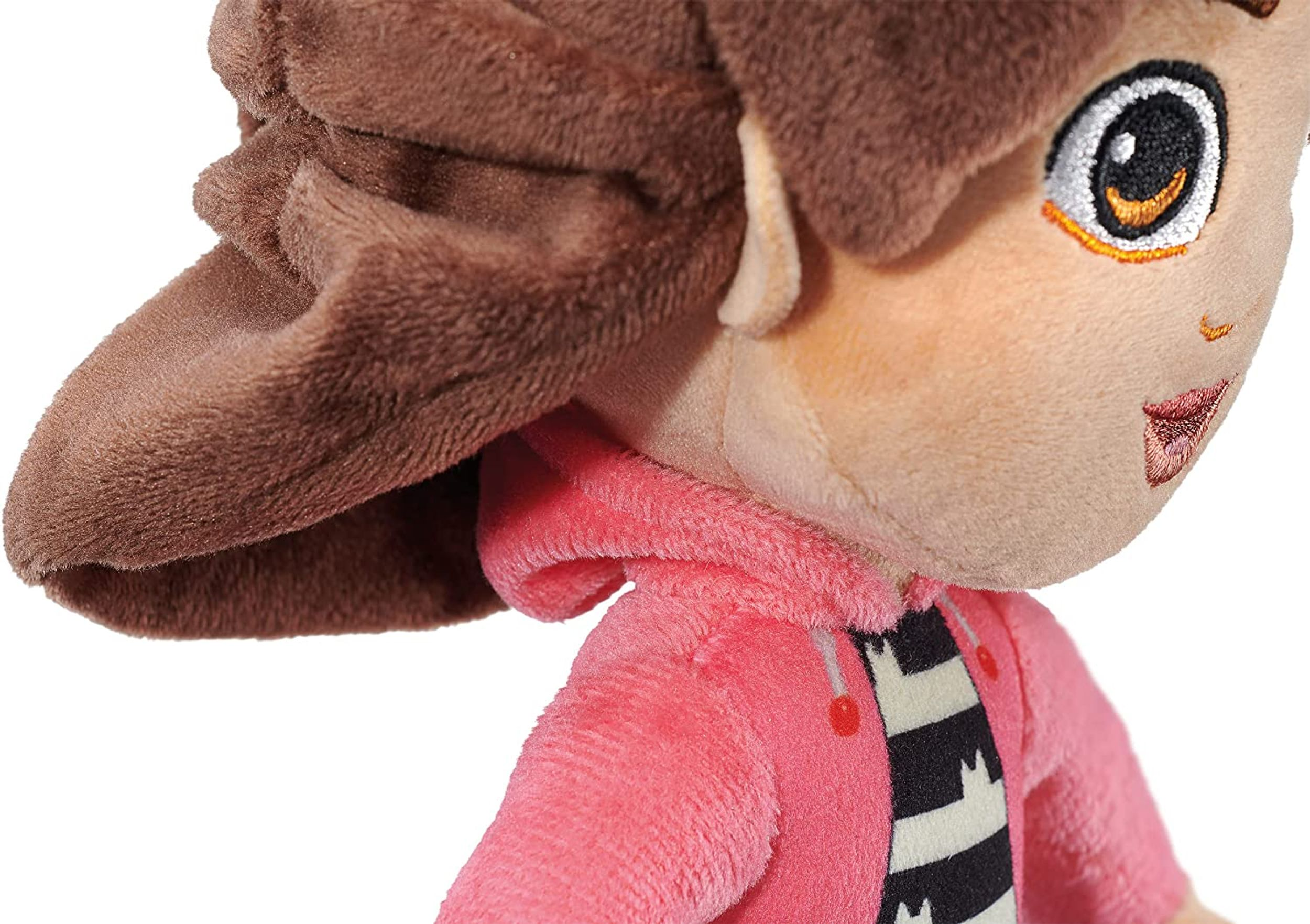 Zbliżenie lalki z brązowymi włosami i w różowej kurtce.