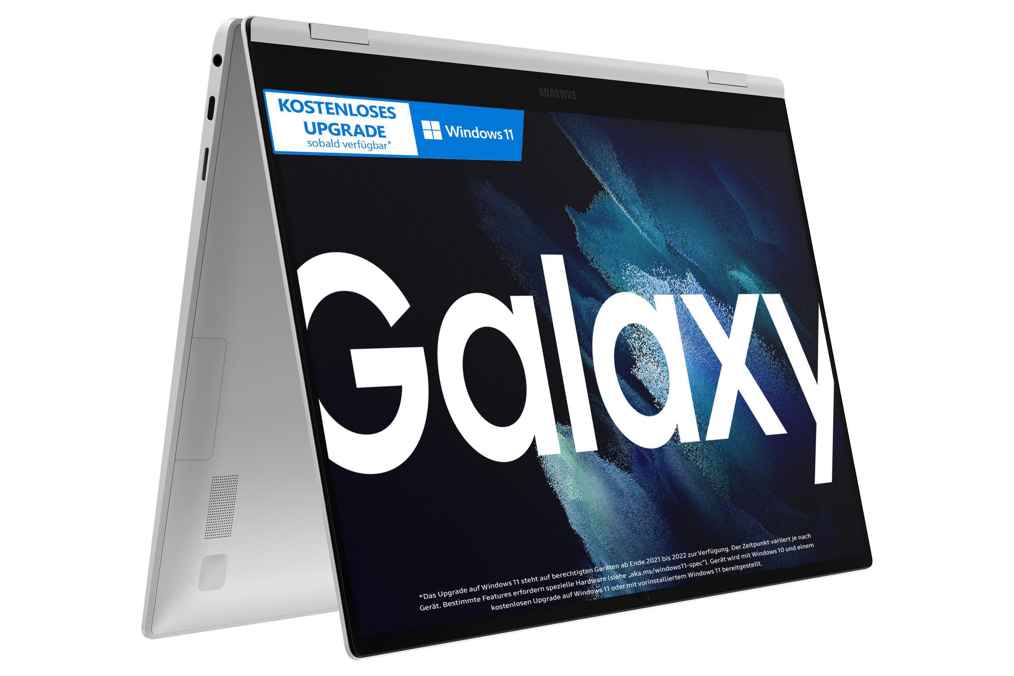 Ein silberner Laptop ist geöffnet und zeigt einen Bildschirm mit 'Galaxy' und einer Windows 11 Upgrade-Benachrichtigung.