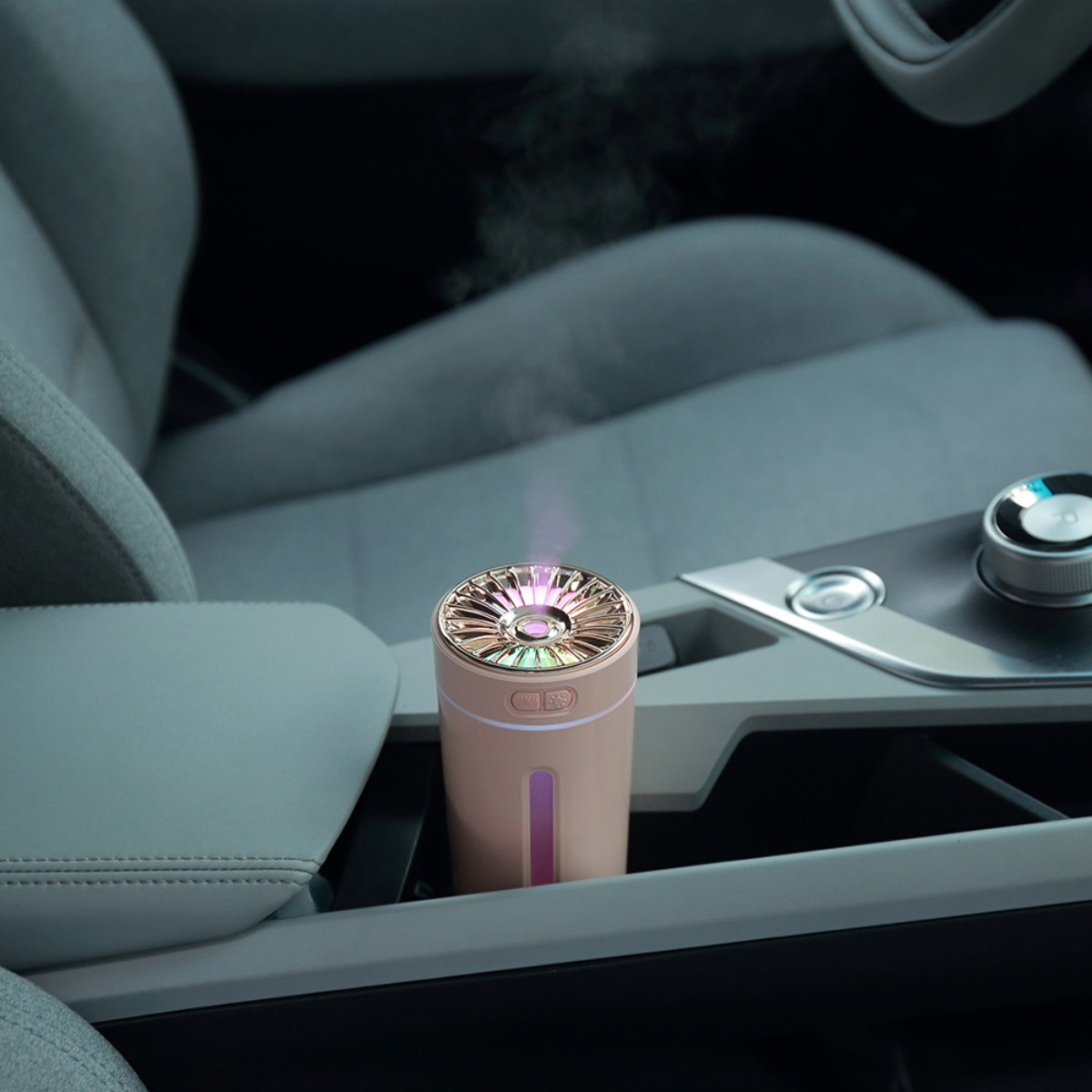 Humidificador rosa y dorado con parte superior colorida. En el interior de un coche.