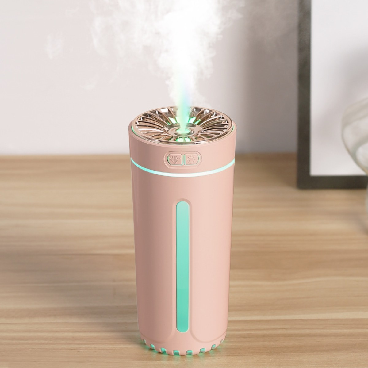 Humidificador rosa con detalles verdes y vapor saliendo.