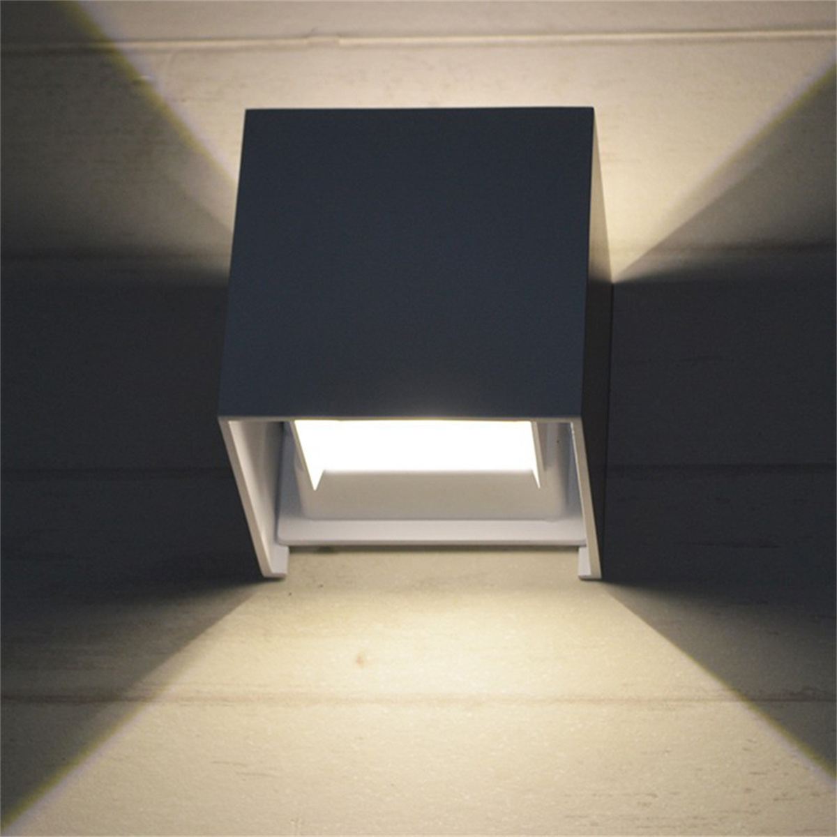 Eine moderne, quadratische, weiße LED-Wandleuchte, die Licht nach unten abstrahlt.