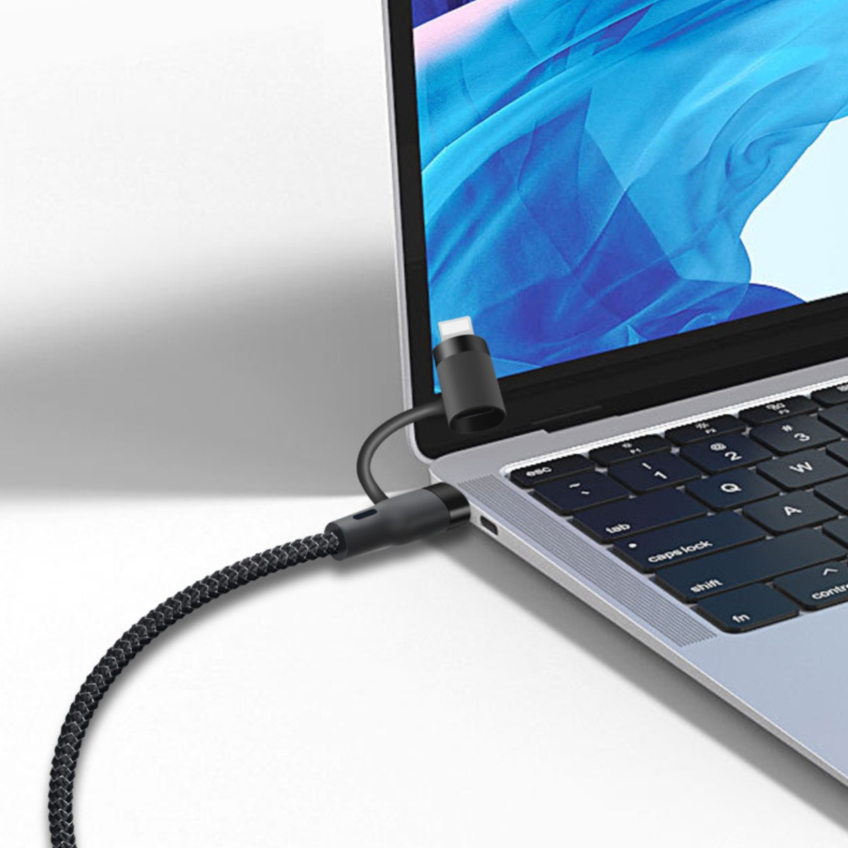 Ein Laptop, verbunden mit einem schwarzen Kabel mit USB-C-Anschluss, der in den Laptop gesteckt ist.