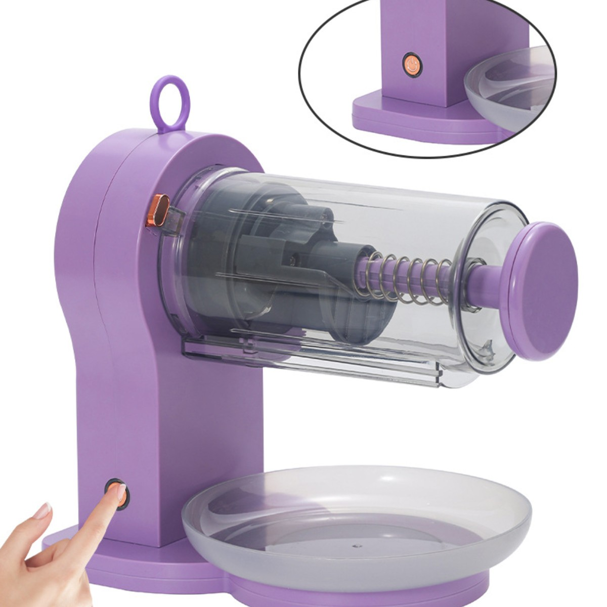 Ein lila Anspitzer, eine transparente Kammer, ein Finger drückt den Einschaltknopf.