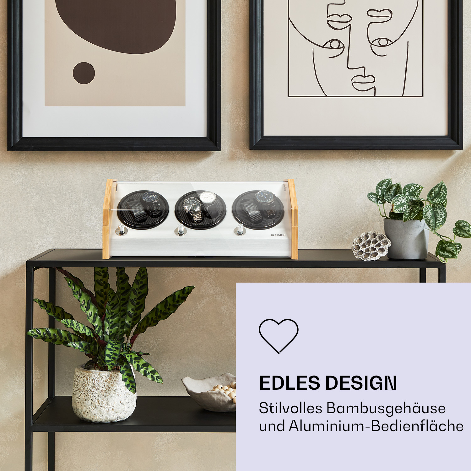 Ein Uhrenbeweger aus Holz und Glas mit drei Uhren auf einem schwarzen Regal.