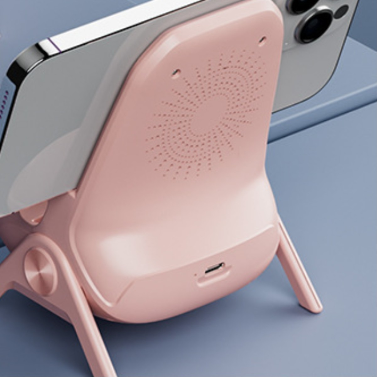 Ein rosa Telefonständer mit einem Telefon darauf. Es hat ein Lautsprecherdesign auf der Rückseite.