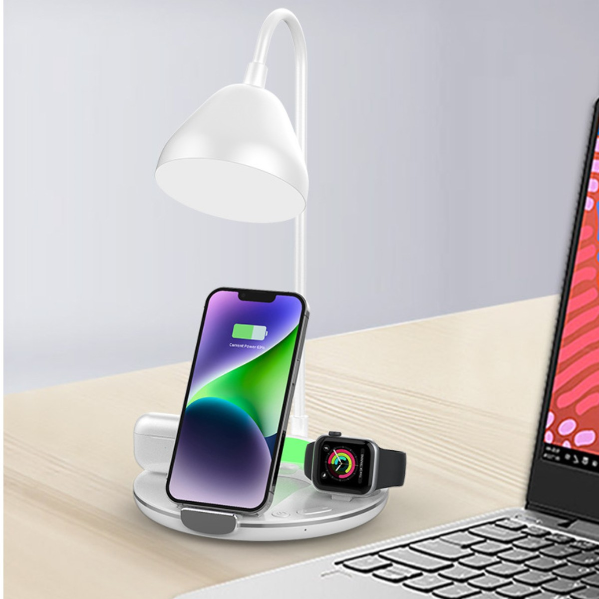 Una lámpara de escritorio, teléfono, auriculares y reloj están sobre un escritorio. El teléfono se está cargando. El reloj muestra una hora.