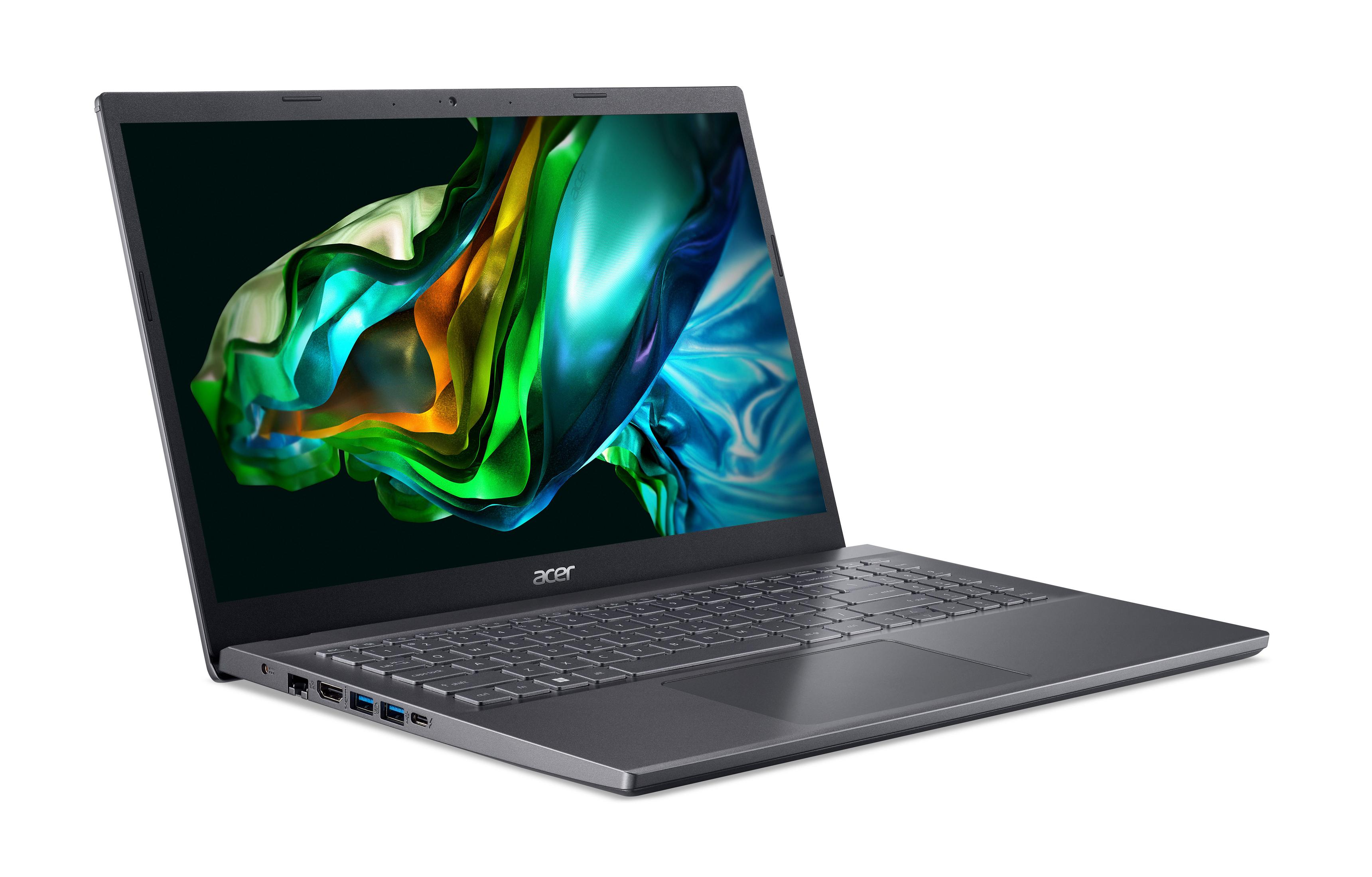 Laptop offen auf weißer Oberfläche, Bildschirm zeigt abstrakte grüne und blaue Farben.