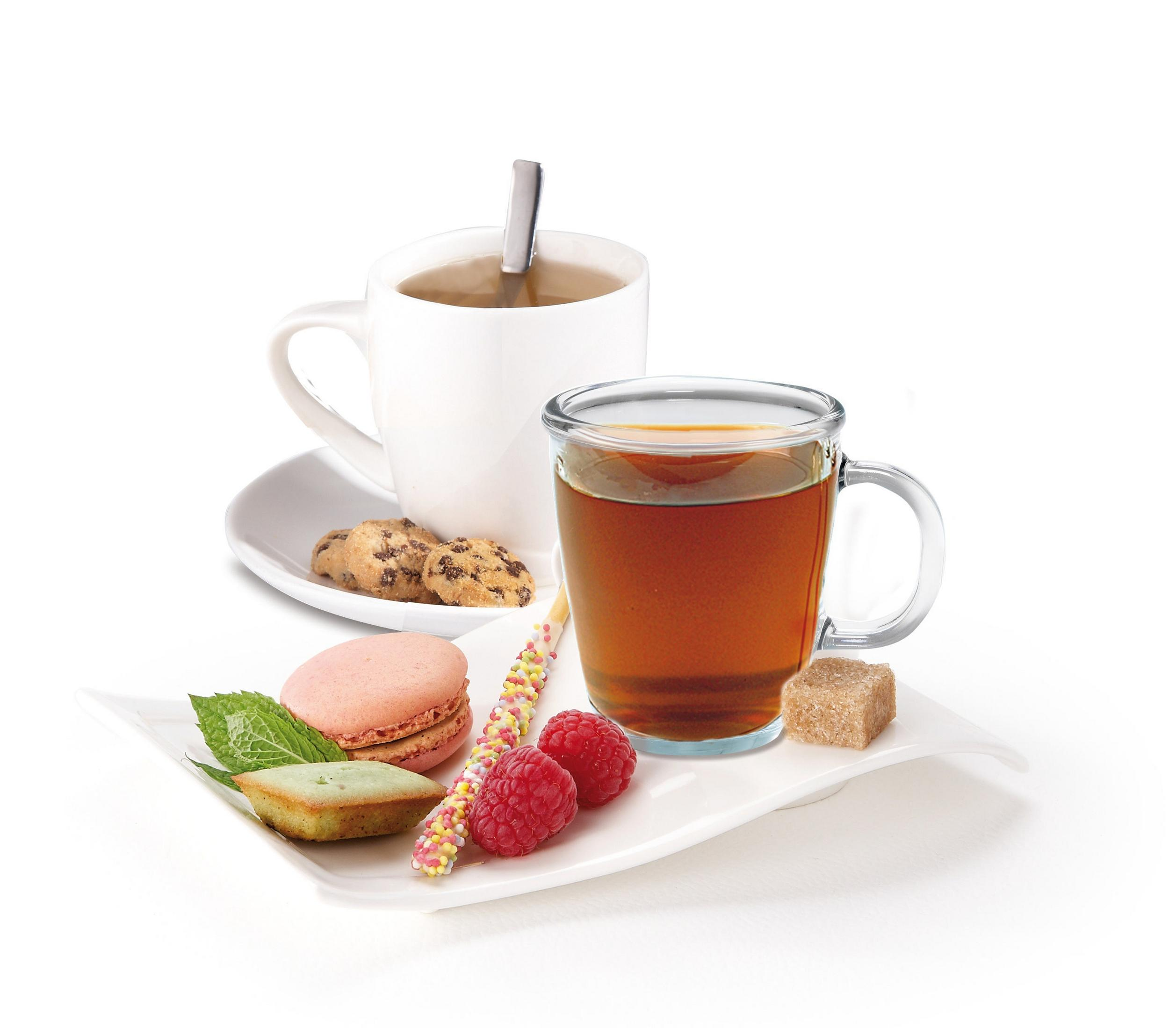 Ein weißer Teller mit Keksen, Makronen und Beeren. Eine Tasse Tee mit einem Löffel ist hinten.