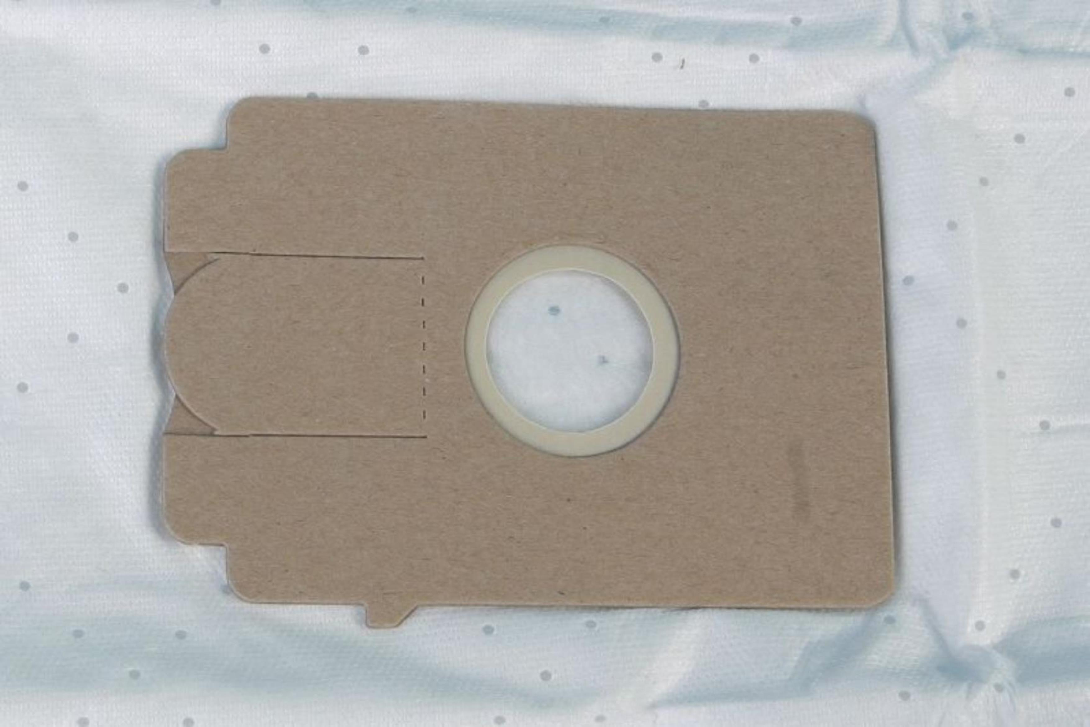 Brauner Staubsaugerbeutel mit kreisförmiger Öffnung, auf blau-weiß gemusterter Oberfläche.