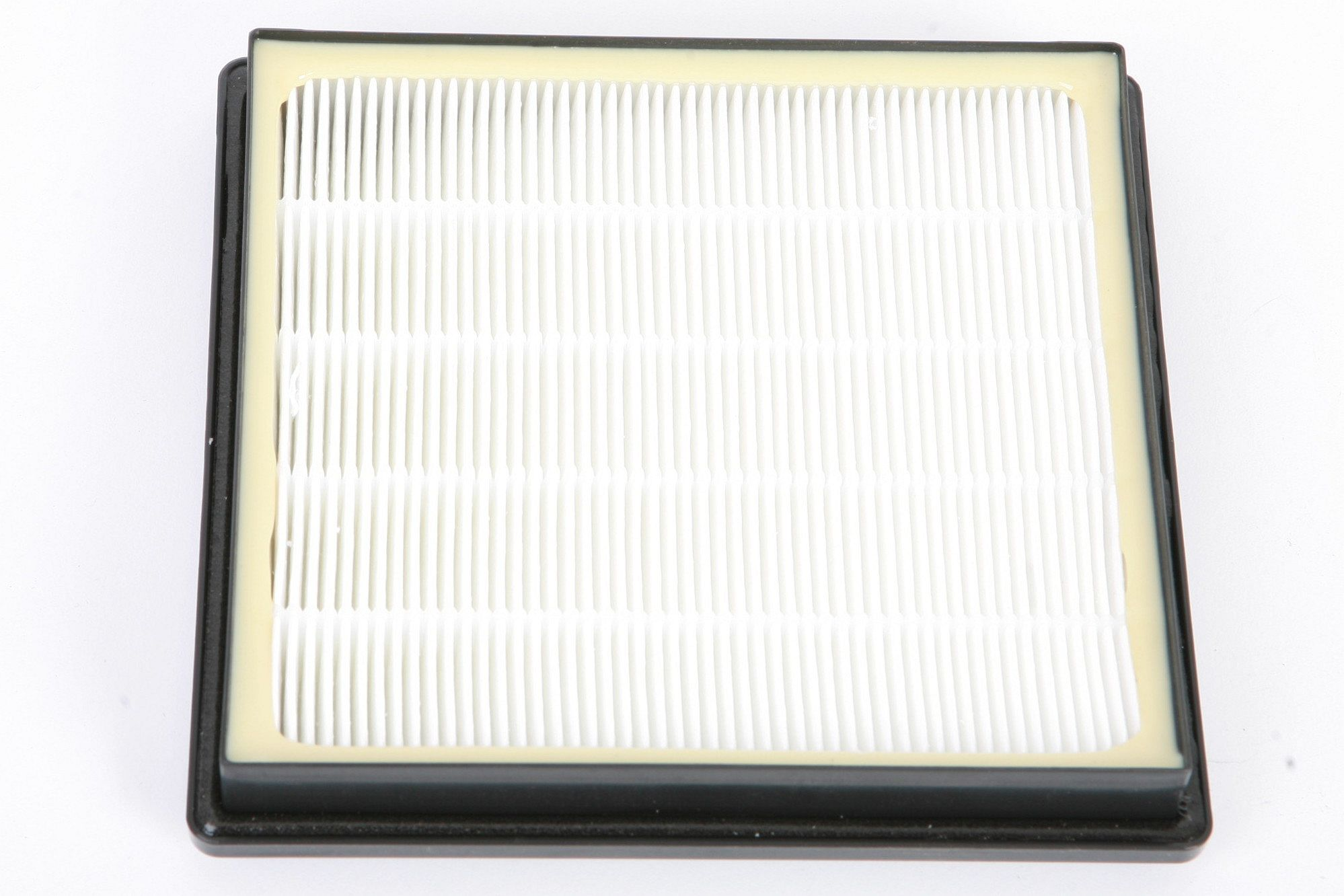 Luftfilter mit weißem, plissiertem Filtermedium und schwarzem Rahmen. Weißer Hintergrund.
