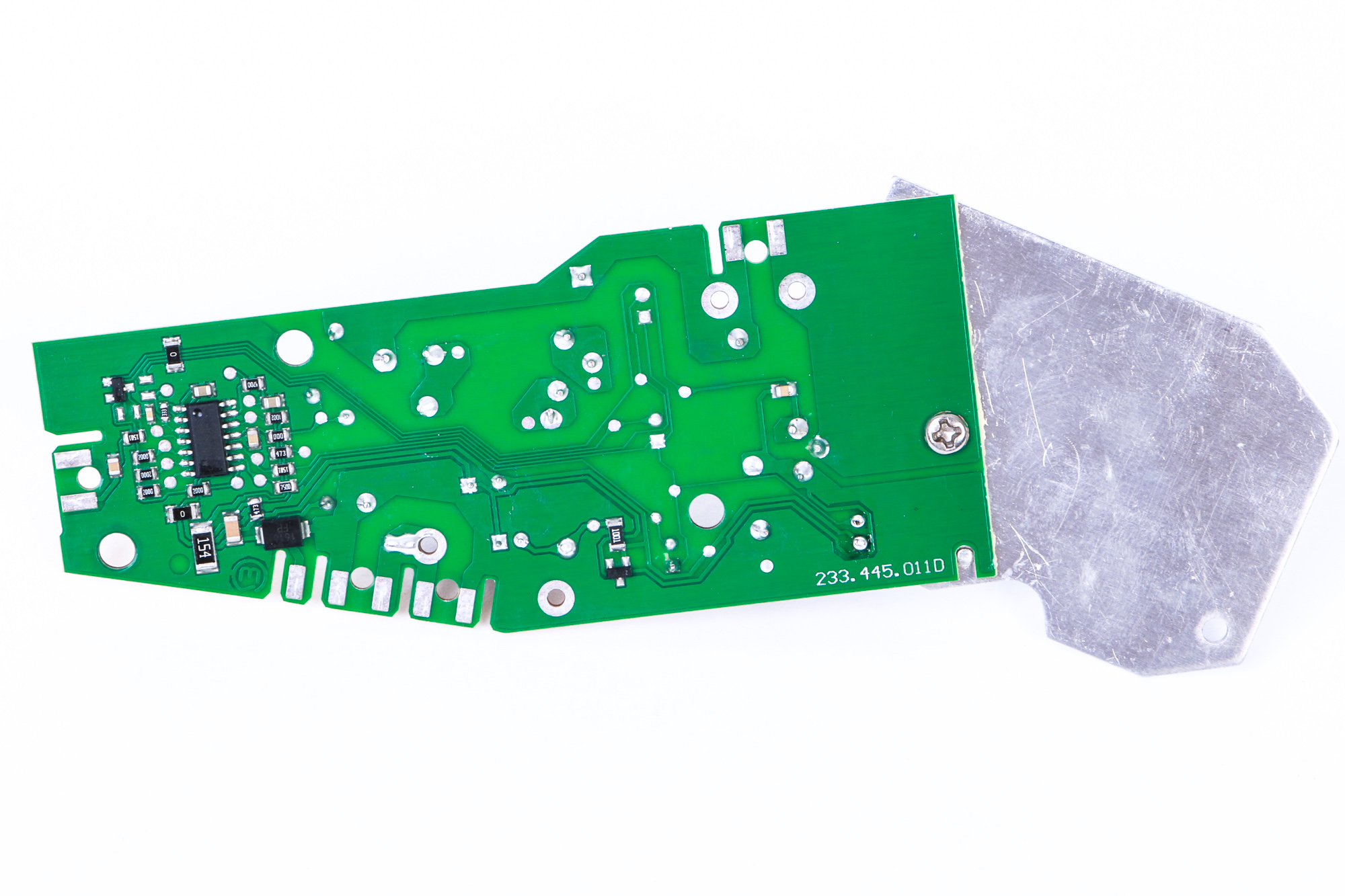 Eine grüne Leiterplatte mit elektronischen Bauteilen und einer Metallplatte.