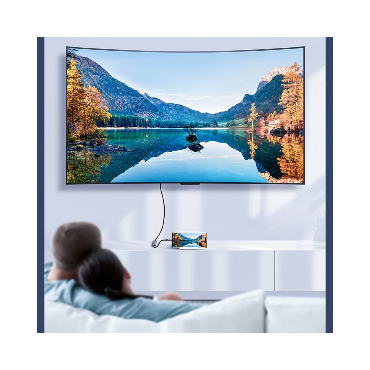 Ludzie oglądający telewizję. Telewizor z zakrzywionym ekranem wyświetla scenę jeziora. Małe urządzenie z przodu.