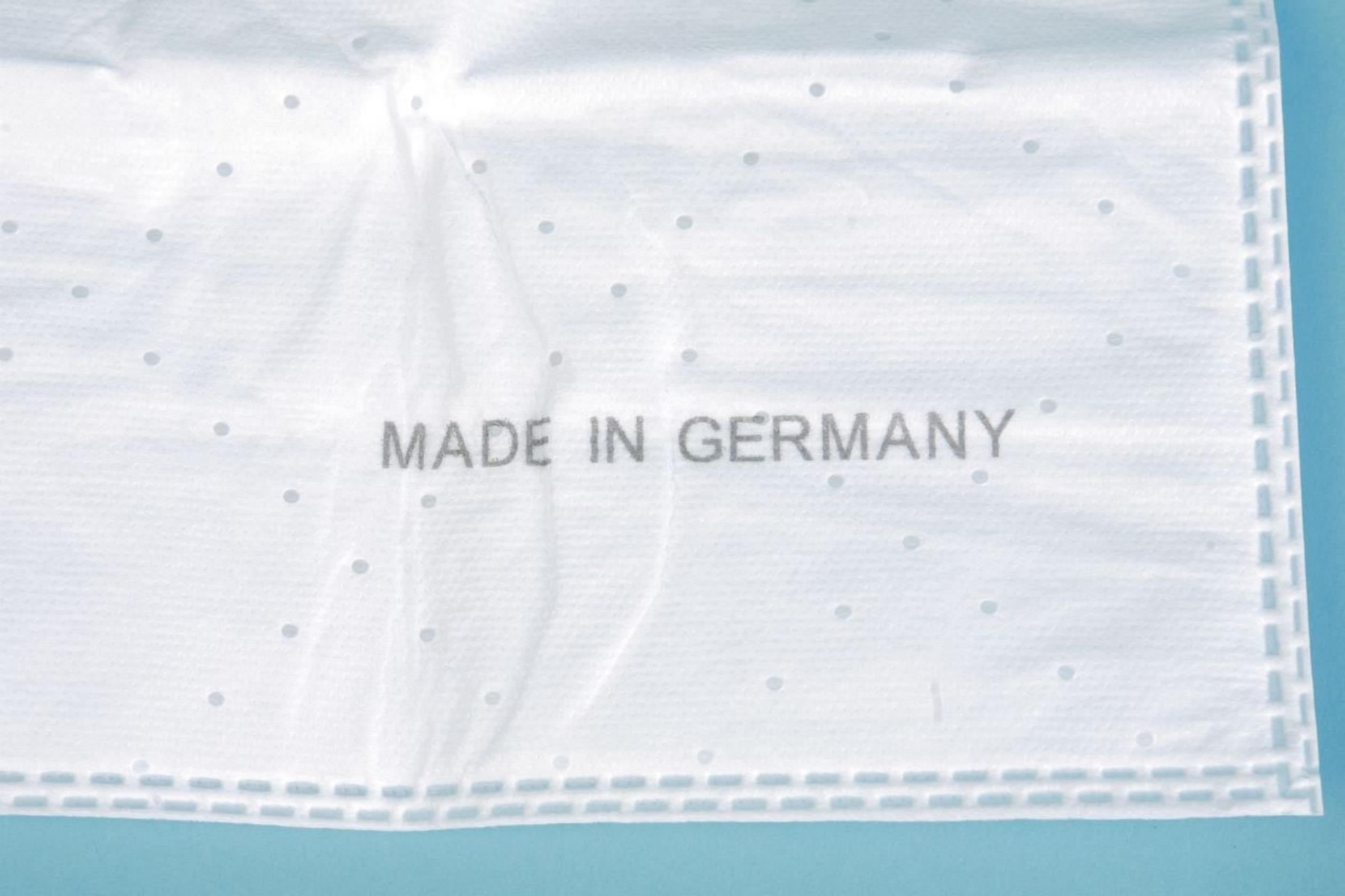 Nahaufnahme eines weißen, perforierten Plastikbeutels mit der Aufschrift 'MADE IN GERMANY'.