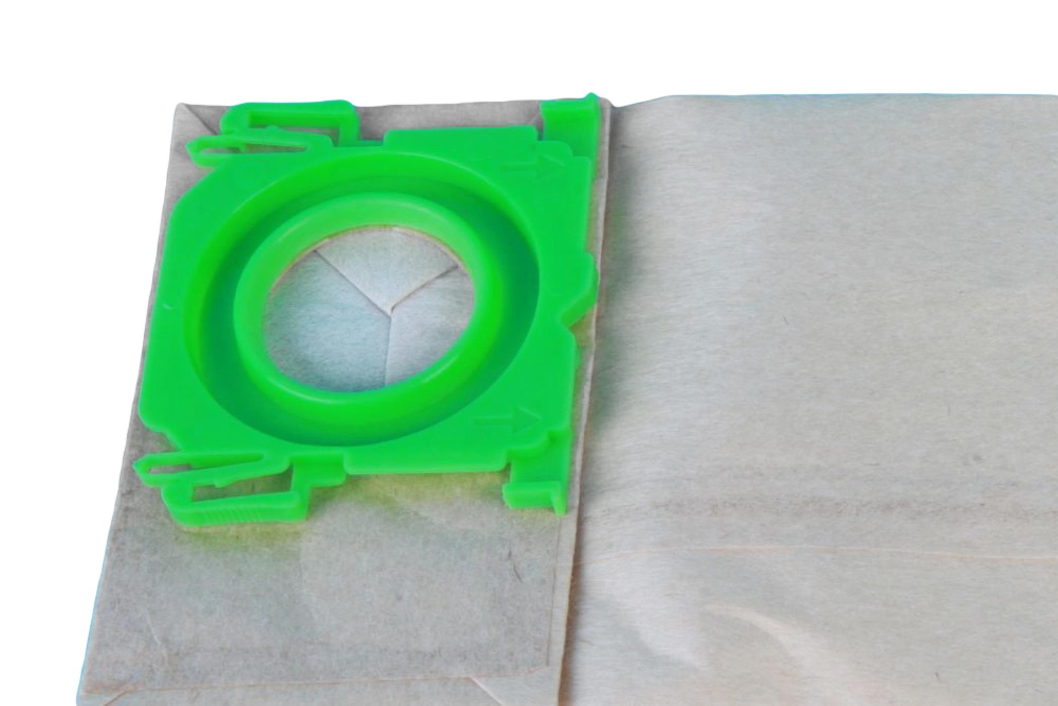 Ein grünes Plastikteil auf einem beigefarbenen Papier-Staubsaugerbeutel. Der Beutel ist offen.