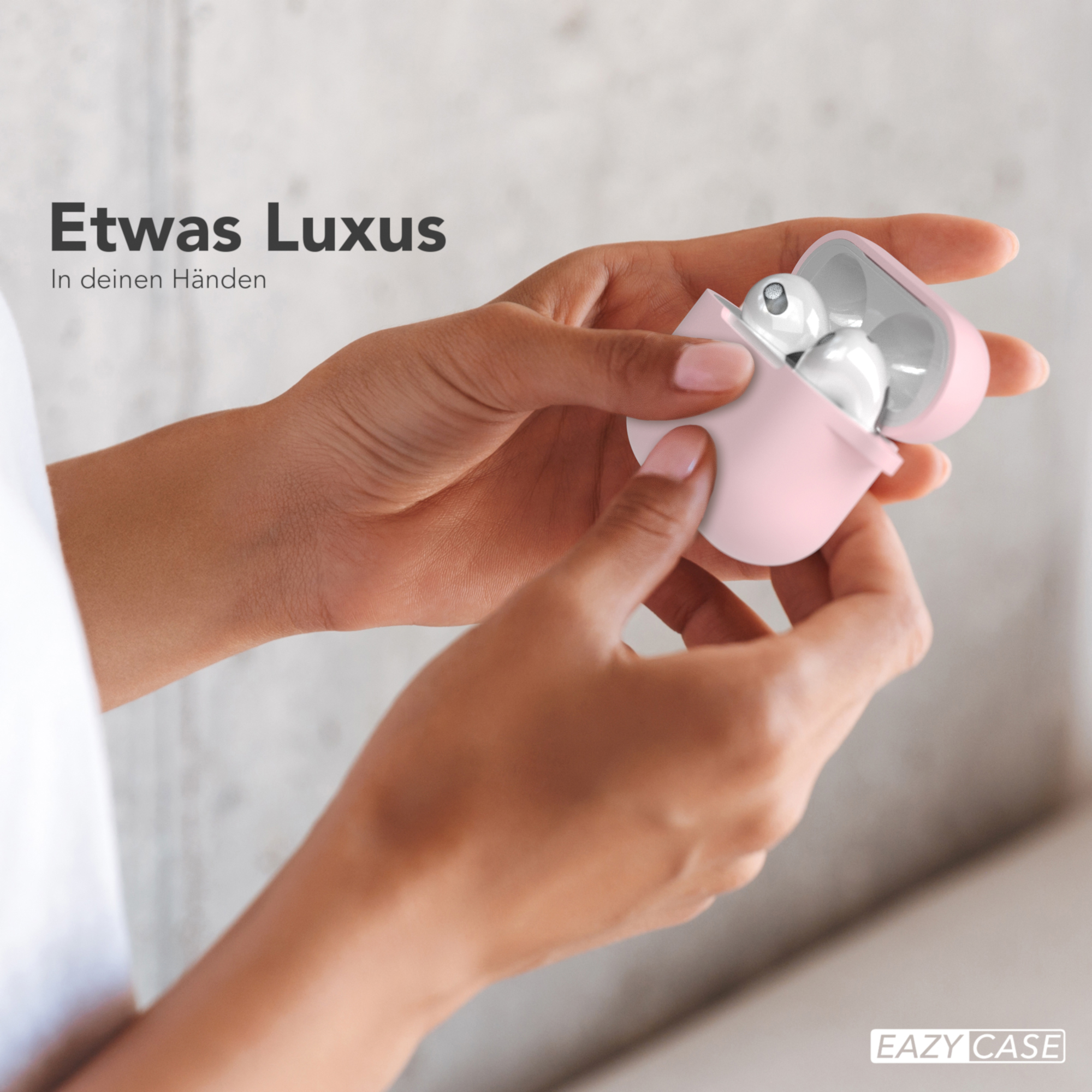 Hände halten ein rosa Etui mit weißen Ohrhörern, mit dem Text 'Etwas Luxus'.