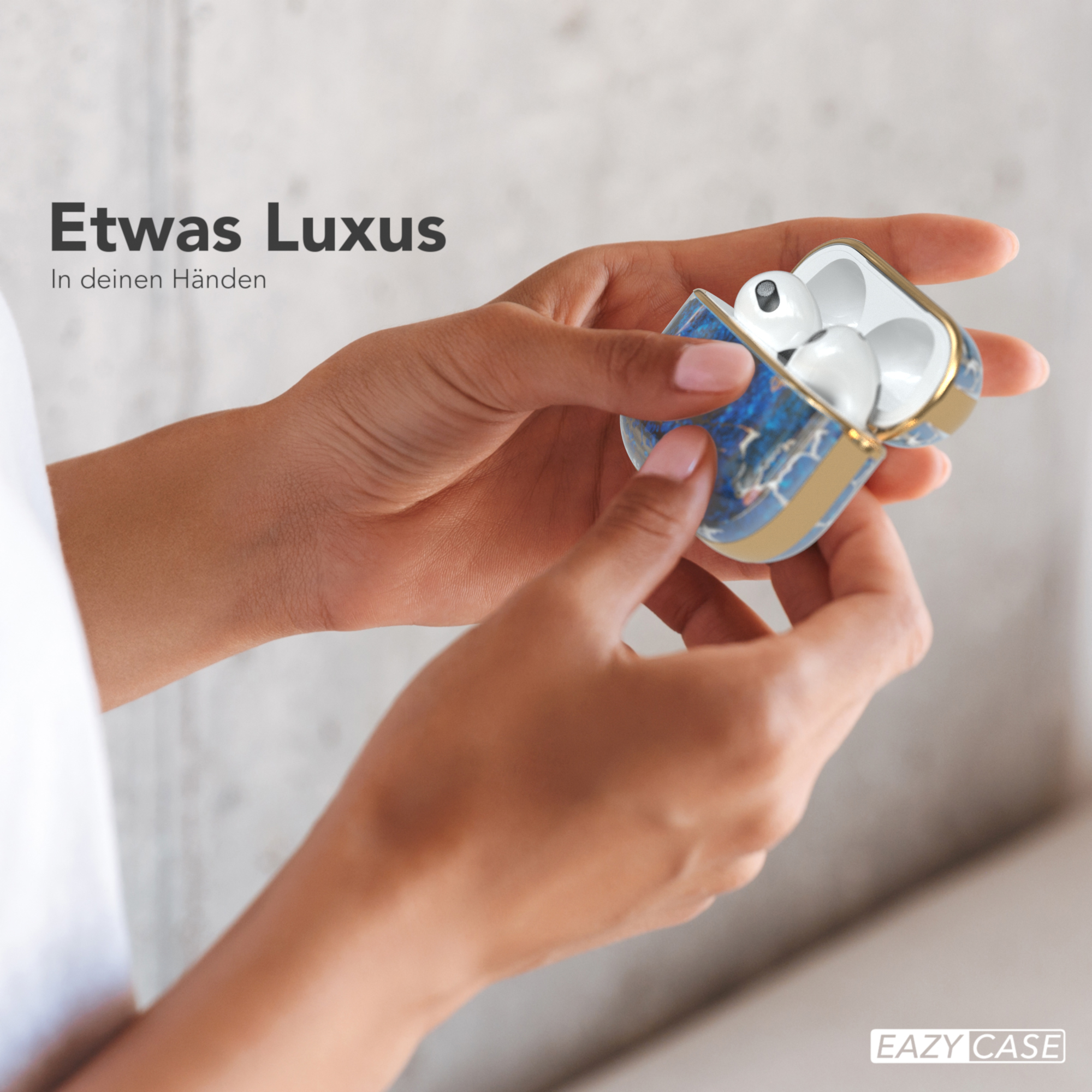 Hände halten geöffnetes AirPods-Etui mit goldfarbenem Rand. Weiße AirPods, Luxusgefühl.
