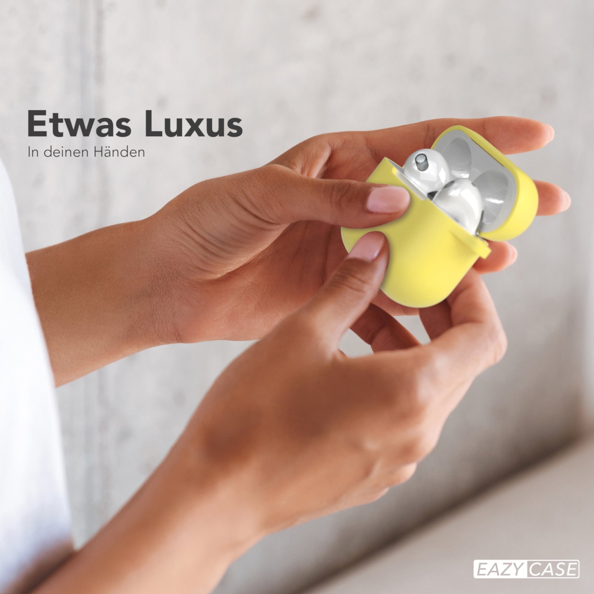 Hand hält eine gelbe Ohrhörerhülle, die sich öffnet und Ohrhörer zeigt. Der Text lautet 'Etwas Luxus'.