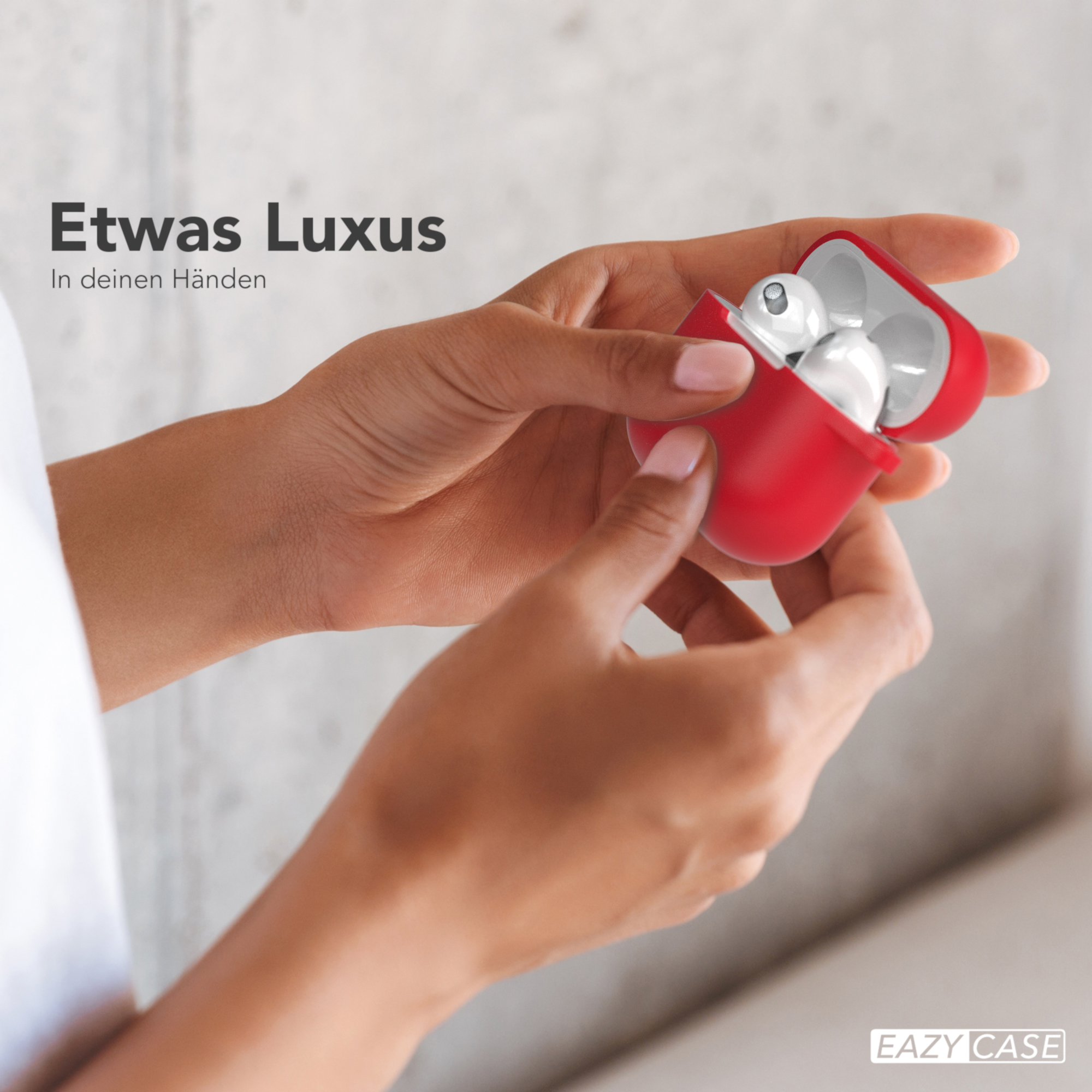 Hände, die eine rote Hülle halten, öffnen sich und zeigen weiße Ohrhörer. Text: Etwas Luxus In deinen Händen.