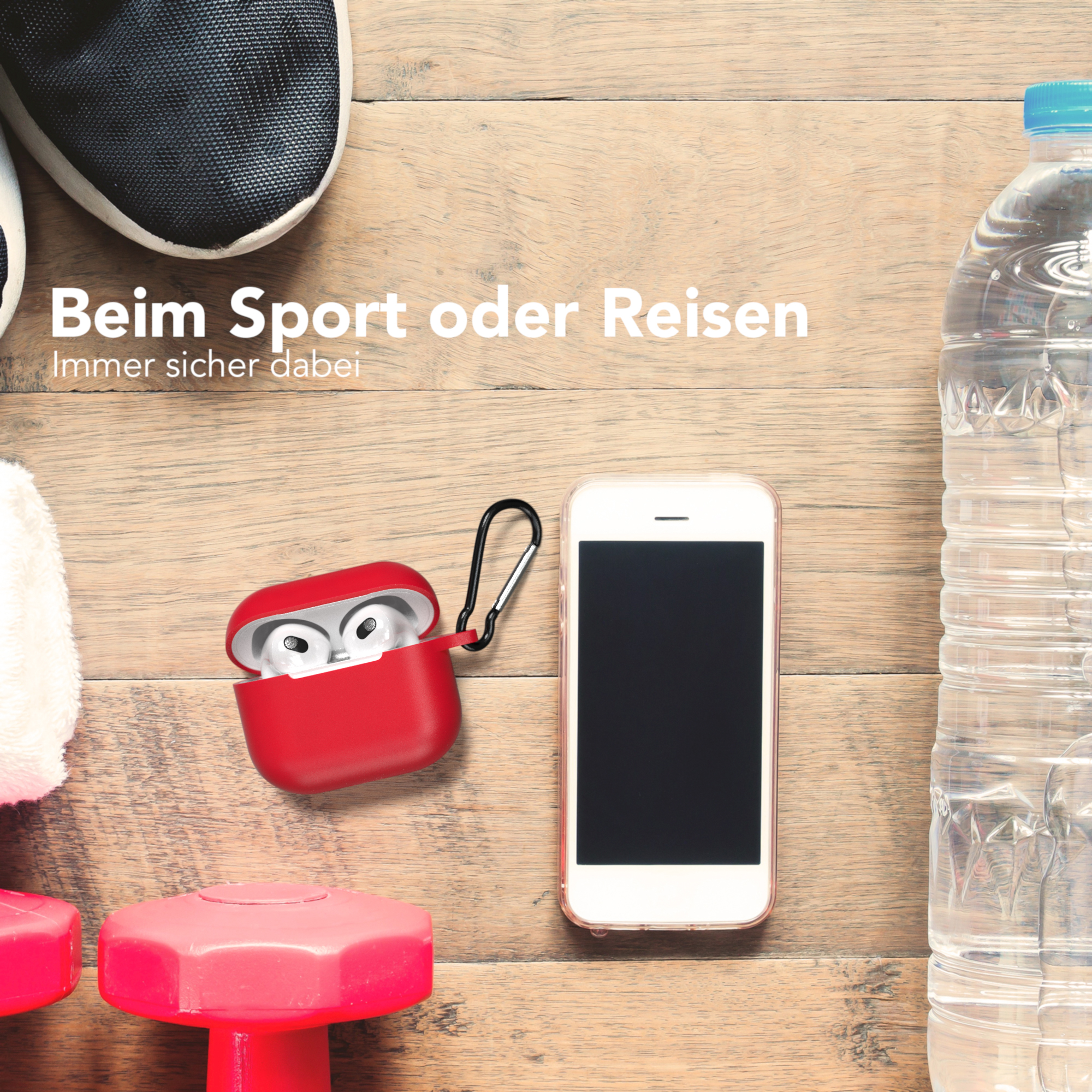 Ein rotes Kopfhörer-Etui mit einem schwarzen Karabiner, neben einem Telefon, einer Wasserflasche und Gewichten.