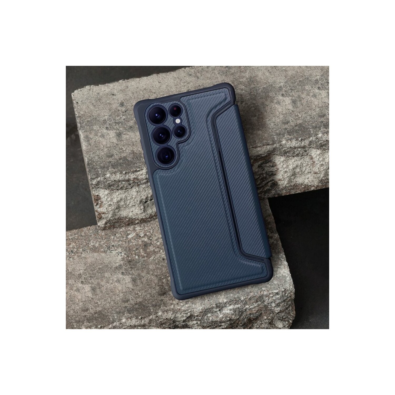 Custodia per telefono blu scuro su superficie ruvida in pietra con lenti della fotocamera e cornice nera.