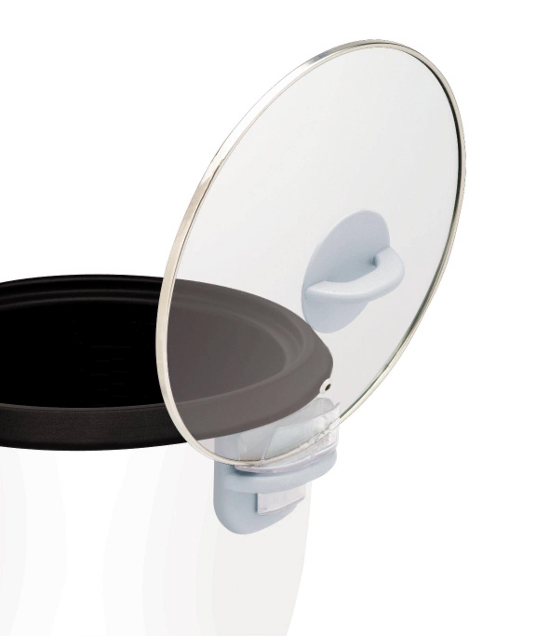 Biały garnek do ryżu z częściowo otwartą szklaną pokrywą i czarnym garnkiem wewnętrznym. Białe tło.