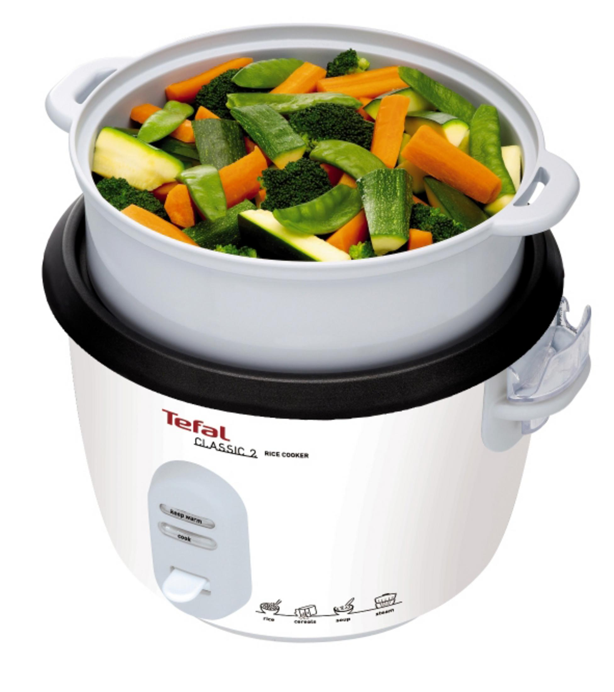 Biały garnek do gotowania ryżu z warzywami w parowarze. Białe tło.