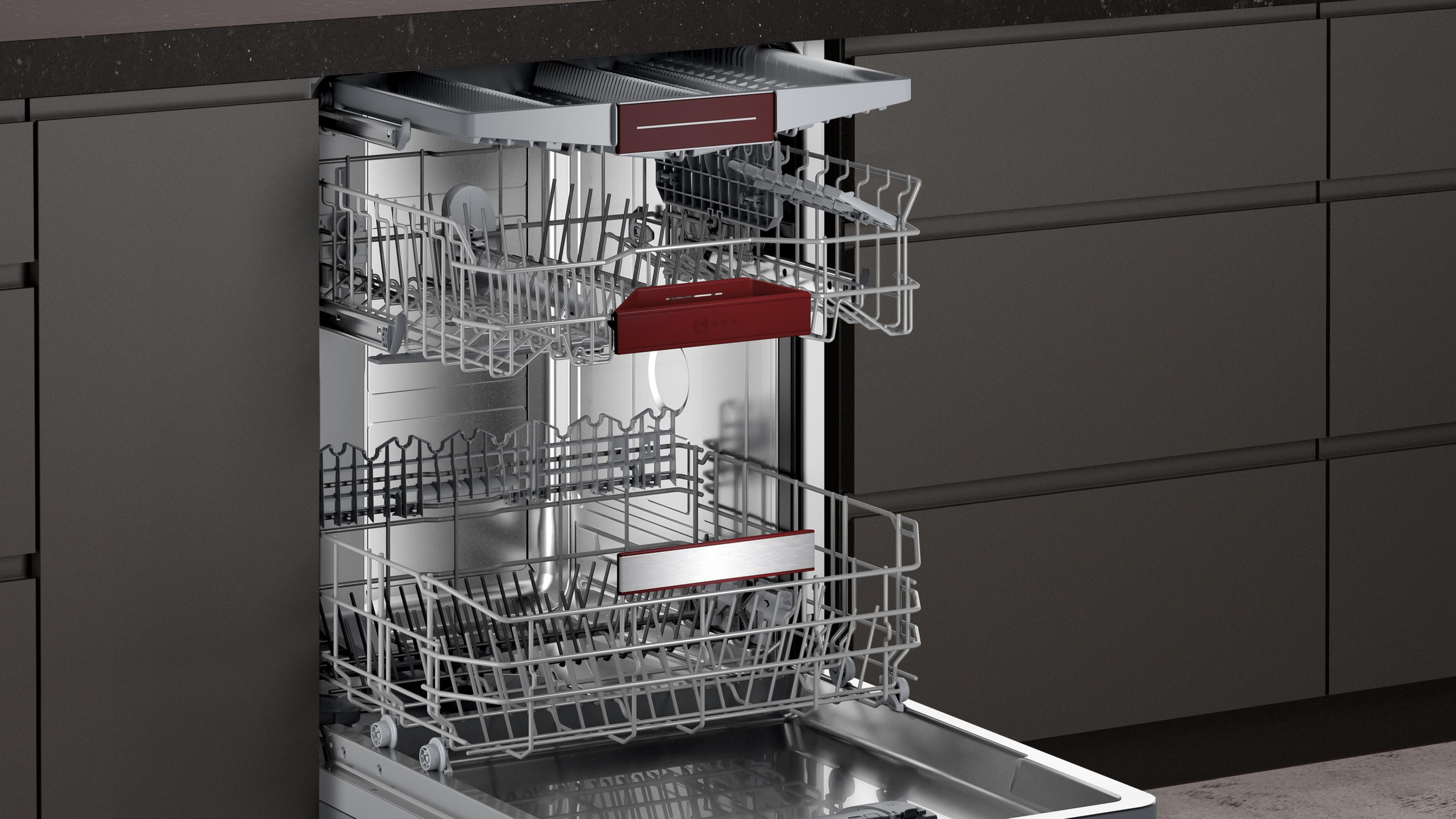 Open dishwasher with two racks holding dishes. Stainless steel interior with dark gray exterior.