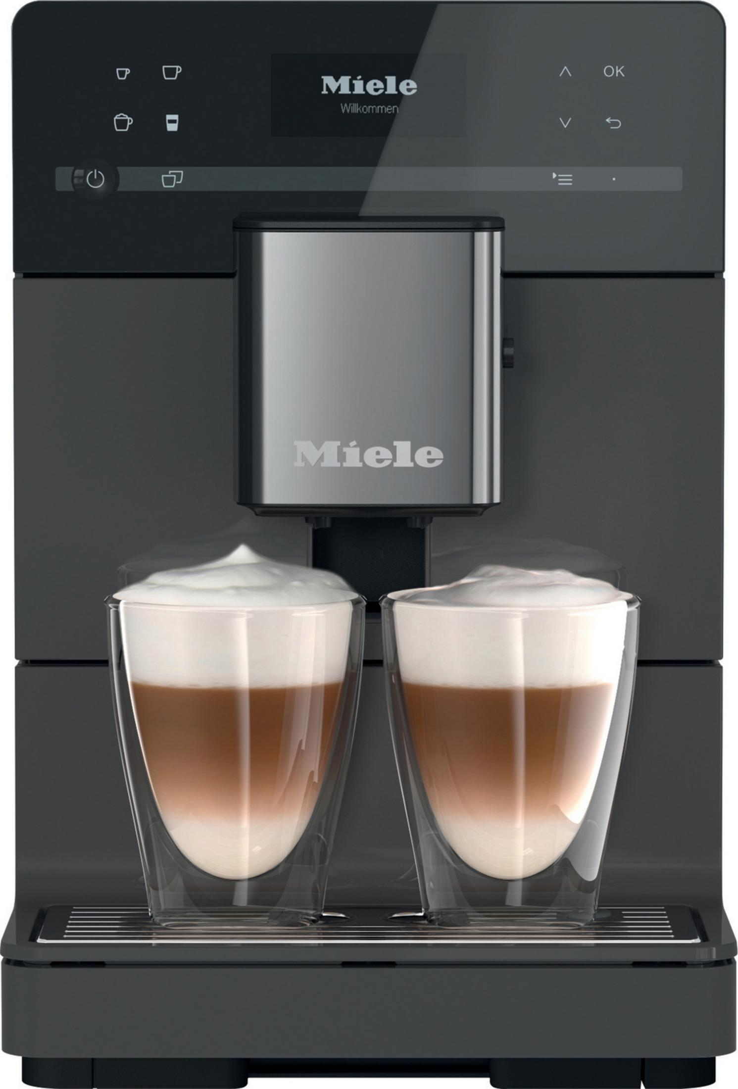 Eine schwarze Kaffeemaschine mit zwei Gläsern Latte Macchiato.