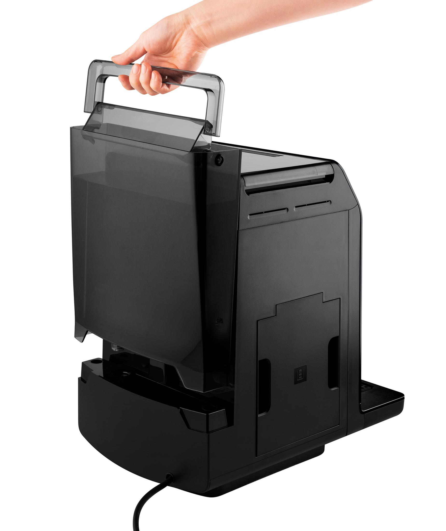 Ręka wyciąga zbiornik na wodę z czarnego ekspresu do kawy.